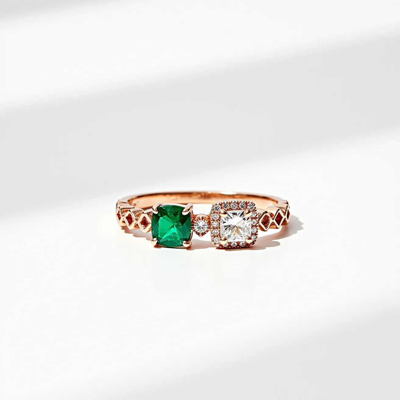 This emerald ring features a striking cushion-cut emerald set in a prong setting alongside a cushion-cut diamond, which is surrounded by a delicate halo of smaller diamonds. The band is crafted from rose gold and is intricately designed with geometric patterns, adding a touch of elegance and uniqueness to the piece. The combination of rich green and sparkling white stones, together with the warm tone of the rose gold band, creates a visually captivating and harmonious design.