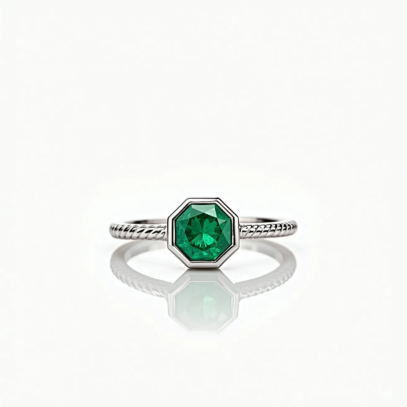 This emerald ring features a stunning emerald gemstone, cut into an octagonal shape and set in a sleek bezel setting. The stone is brilliantly green, exhibiting a vibrant hue that captures light beautifully. The band is crafted from a polished metal, likely white gold or platinum, showcasing a twisted rope design that adds a touch of elegance and texture. The setting securely holds the emerald in place, and the overall design is minimalist yet sophisticated, highlighting the gemstone as the centerpiece of the piece.