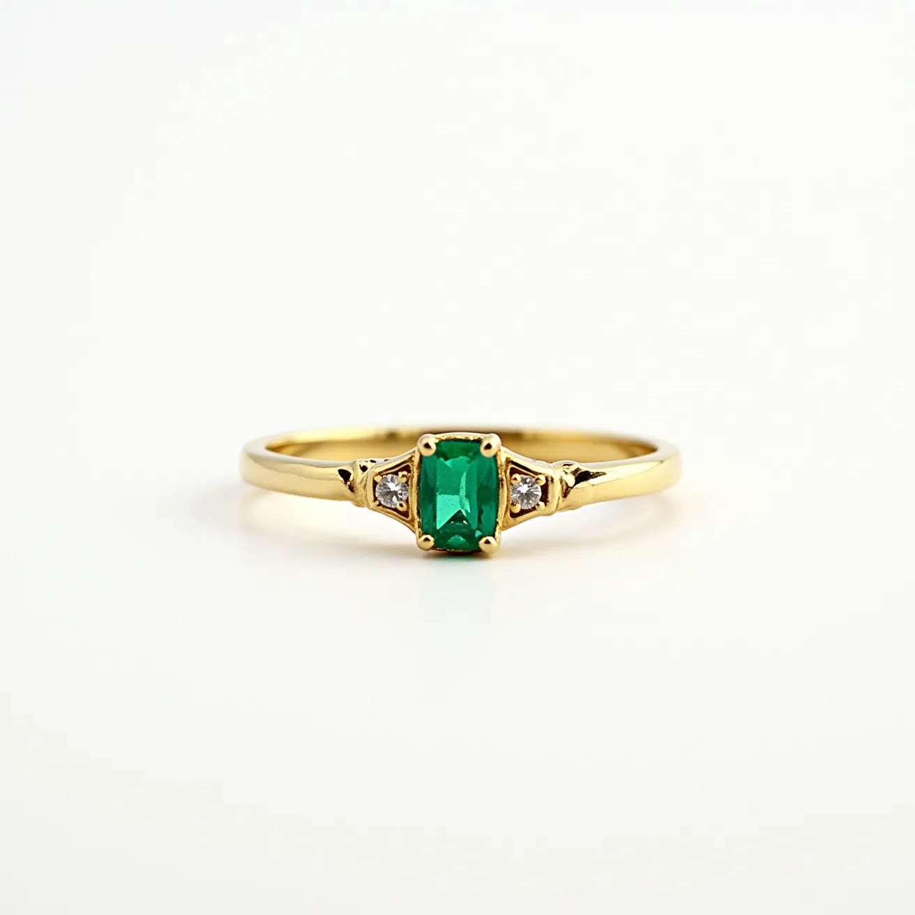 This emerald ring features a central emerald-cut emerald set in a four-prong gold setting, which enhances the rich green color of the gemstone. Flanking the central stone are two small triangular-cut diamonds, each nestled in its prong setting, adding a touch of sparkle and contrast. The band itself is crafted from polished gold, providing a classic and elegant framework that complements the vibrancy of the emerald and the brilliance of the diamonds. The overall design is sophisticated and timeless, suitable for various occasions.