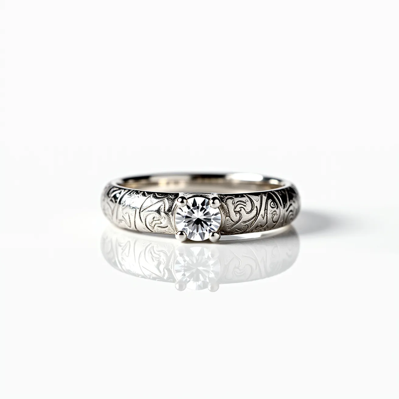 This engraved ring features intricate designs along its band, likely crafted from a polished metal such as white gold or platinum, which provides a sleek, reflective surface. At its center, a prominent round-cut stone, potentially a diamond, is securely held in place by a traditional prong setting, allowing maximum light to enhance its brilliance. The prongs are delicate yet sturdy, seamlessly integrated into the band. Overall, the ring combines elegance with craftsmanship, highlighted by the detailed engravings and the striking central gemstone.