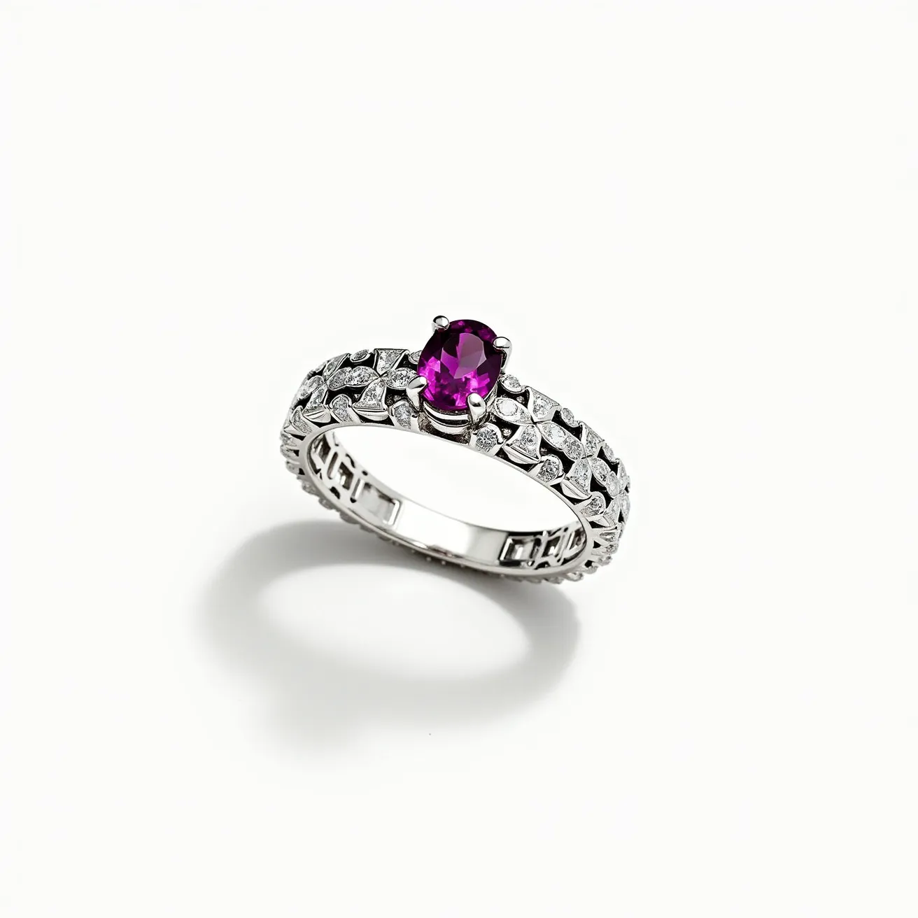 This eternity ring features a stunning design with a central amethyst gemstone, cut in an oval shape, securely held in place by a four-prong setting. The band is crafted from white metal, possibly white gold or platinum, and is adorned with a series of smaller round-cut diamonds that are embedded throughout. These diamonds add to the ring's brilliance and elegance, accentuating the vibrant purple hue of the central amethyst. The ring does not involve any clasp or attachment, as is typical of eternity rings, symbolizing an unending circle of love.