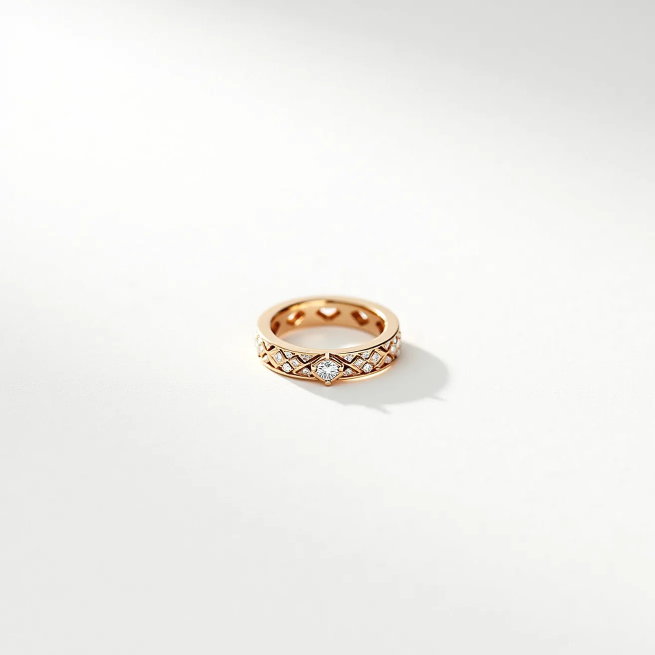 This eternity ring is crafted from rose gold, featuring an intricate lattice design around its band. Set within this lattice are multiple small, round-cut diamonds, each securely bezel set, forming a continuous and elegant sparkling effect. The ring is characterized by a central diamond, which is slightly larger than the others and set in an elaborate, marquise-shaped frame that enhances its prominence. The overall design showcases precision and refinement, with no visible clasp or attachment, embodying the symbol of eternity through its unbroken circle adorned with shimmering diamonds.