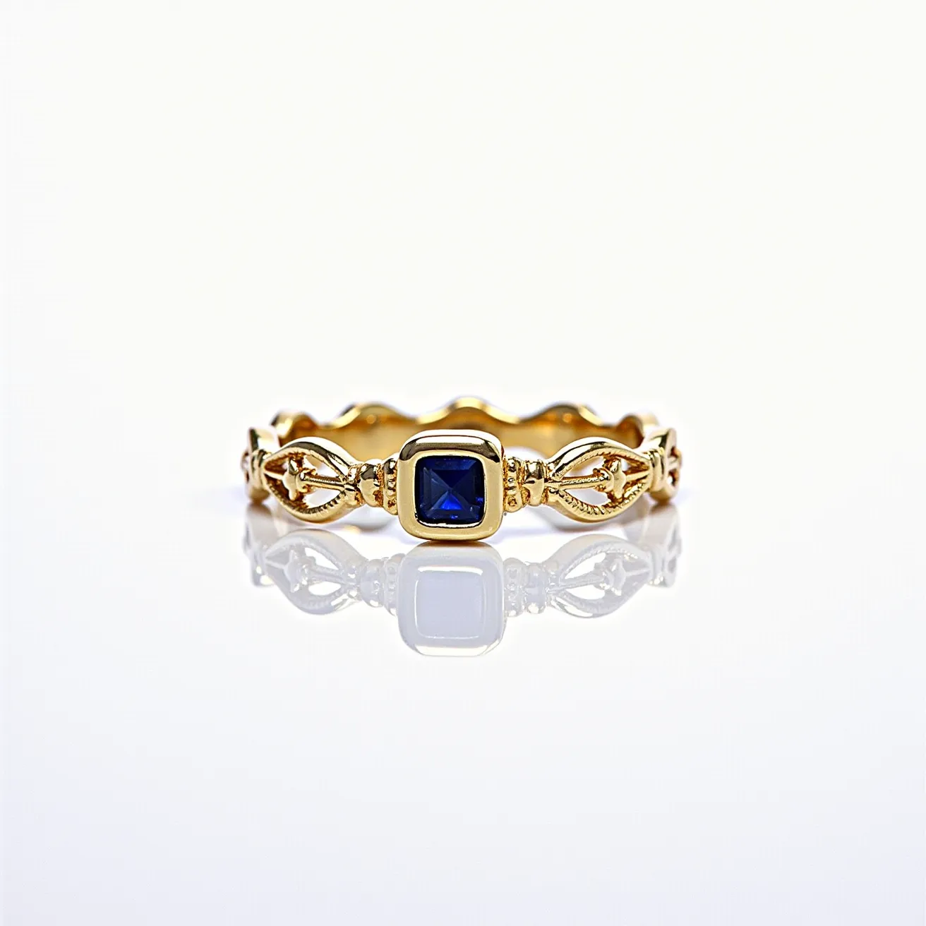 This eternity ring features a striking blue gemstone, cut in a square shape, prominently bezel-set at its center. Crafted from gold, the band showcases intricate detailing, with elegant motifs flanking the central stone, adding an ornate flair to the overall design. The ring's continuous design, typical of eternity bands, symbolizes unending love or commitment.