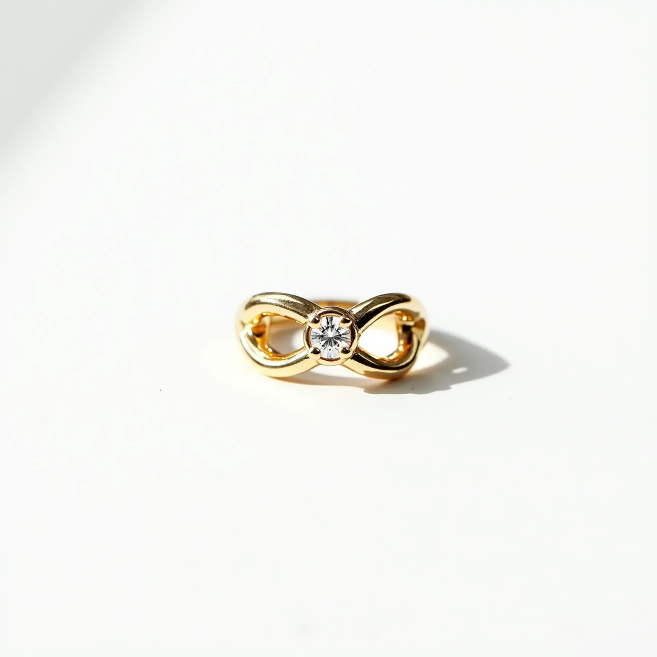 This fidget ring features a sleek infinity band crafted from a polished gold-colored metal. At the center, a single round-cut gemstone, likely a diamond or diamond simulant, is securely set, adding a touch of elegance to the design. The infinity motif allows for a smooth surface, making it both a functional and stylish accessory. This piece combines elements of sophistication with the tactile benefits of a fidget toy.