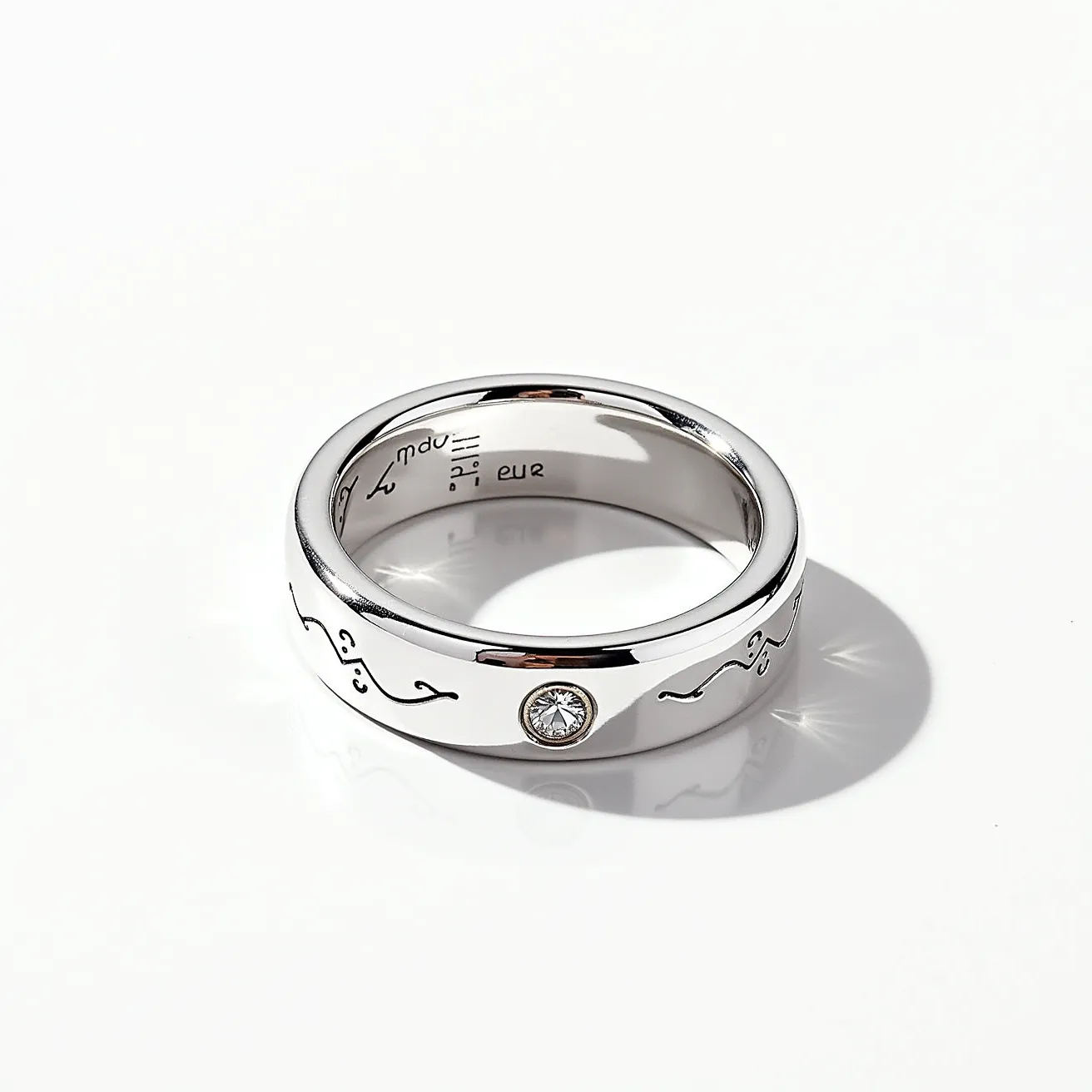 This fidget ring features a sleek, polished metal band that appears to be made of stainless steel or a similar silver-toned material, providing a reflective quality. Embedded within the band is a single round-cut gem, likely a clear crystal or diamond, set in a bezel setting, which secures the gem smoothly within the metal without any prongs. The exterior surface of the band is adorned with engraved symbols or designs, adding an element of intricate detail and personal significance. The interior of the band is slightly rounded, providing a comfortable fit for the wearer.