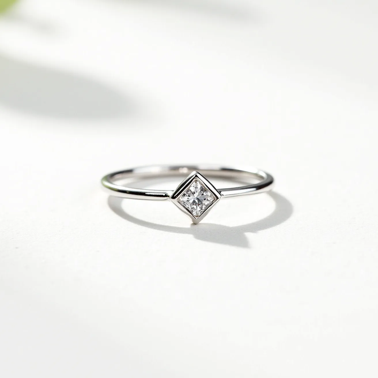 This fidget ring is crafted from a sleek, silver-toned metal, likely sterling silver or white gold, providing a smooth and polished finish. It features a centrally positioned, square-cut gemstone that is likely a diamond, set within a bezel setting for a modern and minimalist look. The slim band complements the understated design, making it both practical and stylish for everyday wear. The absence of any clasp or additional attachments enhances its simplicity and elegance, allowing the wearer to spin or move the ring with ease.