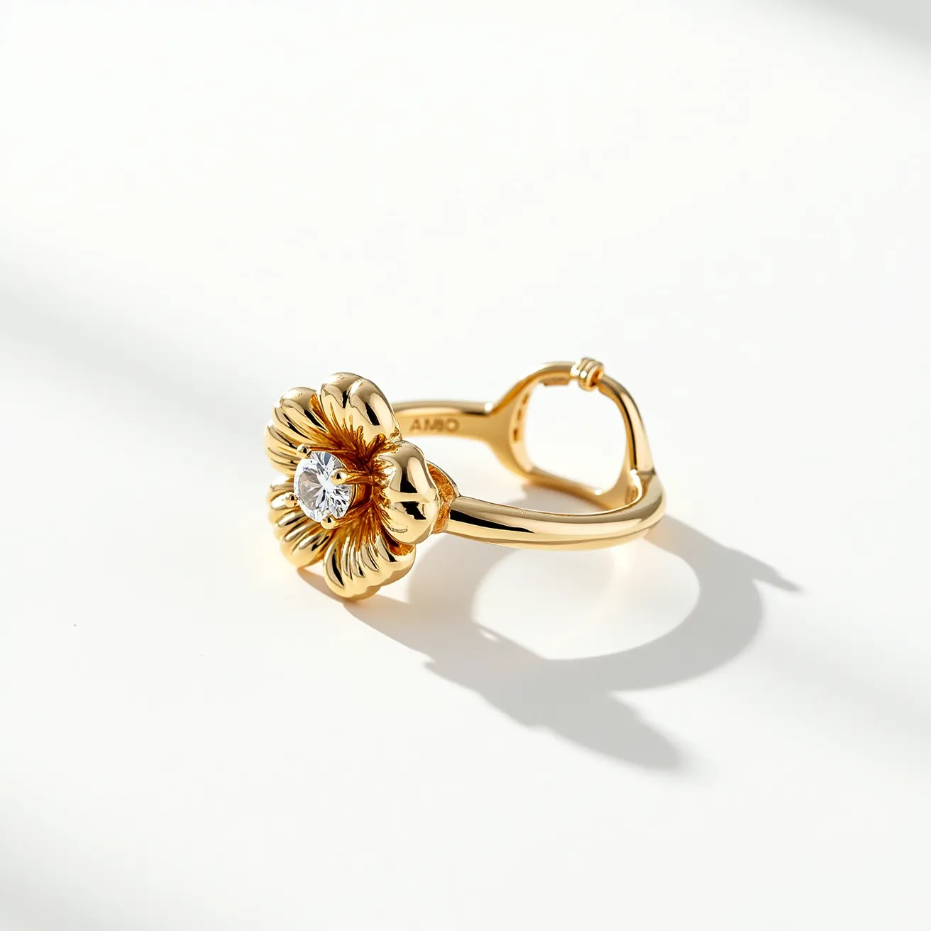 This floral ring features a delicately crafted flower motif with petals made from polished gold. At the center, a single round-cut diamond is securely set, adding a touch of brilliance and elegance to the overall design. The ring's band is smooth and slightly tapered, made from the same gold material, providing a cohesive and luxurious appearance. It includes a hinge clasp, allowing for an adjustable fit and ensuring comfort and security for the wearer. The combination of the floral motif and the sparkling central diamond encapsulates a timeless and sophisticated aesthetic.