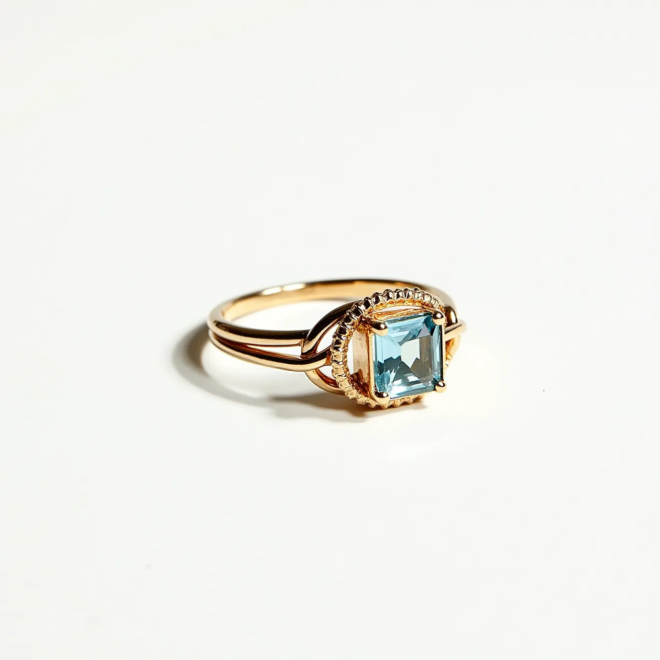 This friendship ring features a delicate gold band that elegantly supports a prominent square-cut blue gemstone. The gem is securely held in place by a detailed bezel setting, which adds a touch of sophistication and charm. The gold surrounding the gemstone is intricately designed, complementing the gem's cool hue with the warmth of the metal. The combination of the gold band and the vibrant blue stone creates a striking contrast, making this ring a beautiful symbol of friendship and lasting bonds.