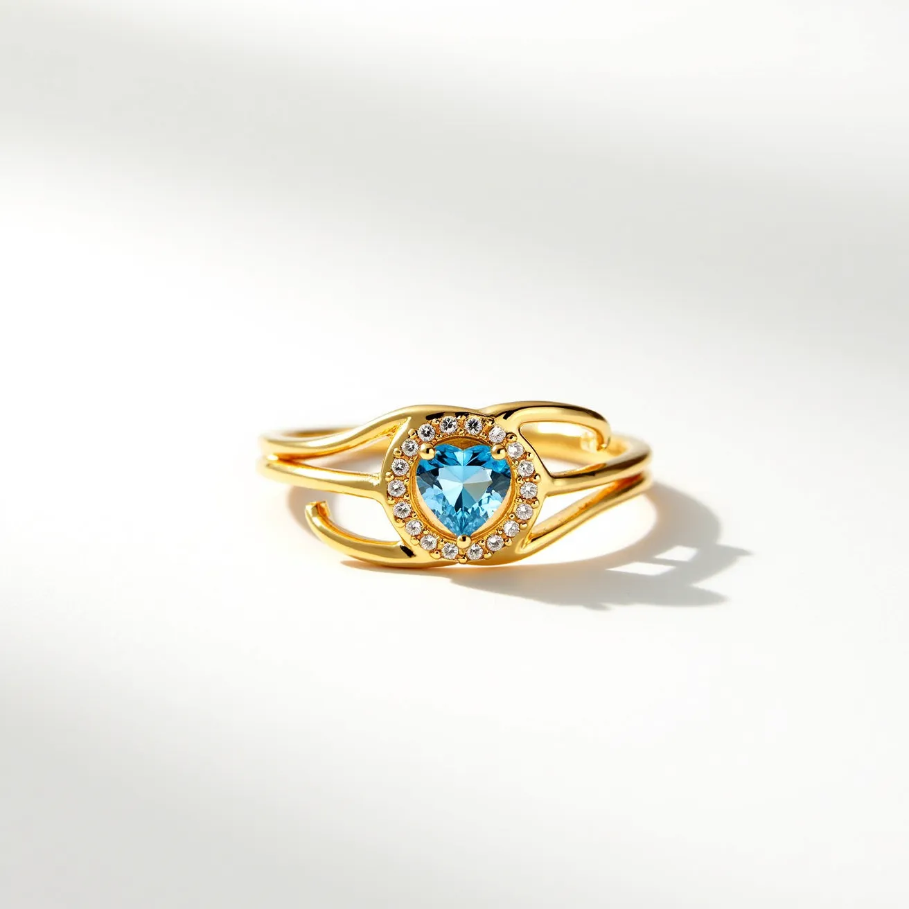 This friendship ring is crafted from a lustrous gold material, featuring a striking blue heart-shaped gemstone at its center. The gem is elegantly cut to highlight its facets and is encircled by a halo of smaller, clear stones, possibly diamonds or cubic zirconia, each set in a prong setting for enhanced brilliance. The band is split on either side, adding a unique and modern touch to its design. There is no clasp or attachment, as is typical with rings.