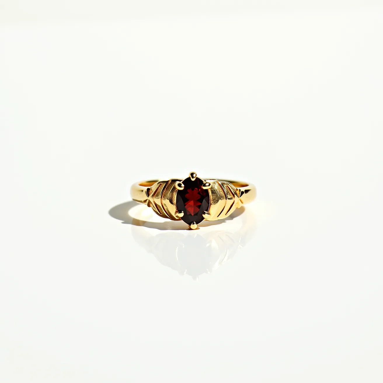 This garnet ring features a richly colored, oval-cut garnet stone set in a beautifully crafted gold band. The garnet is held securely in place by several prongs that form an elegant claw setting, enhancing its deep red hue and sparkle. The band itself is designed with intricate gold detailing on either side of the stone, adding a touch of sophistication and artistry to the piece. The combination of the bold garnet and the warm gold creates a classic and eye-catching statement ring.