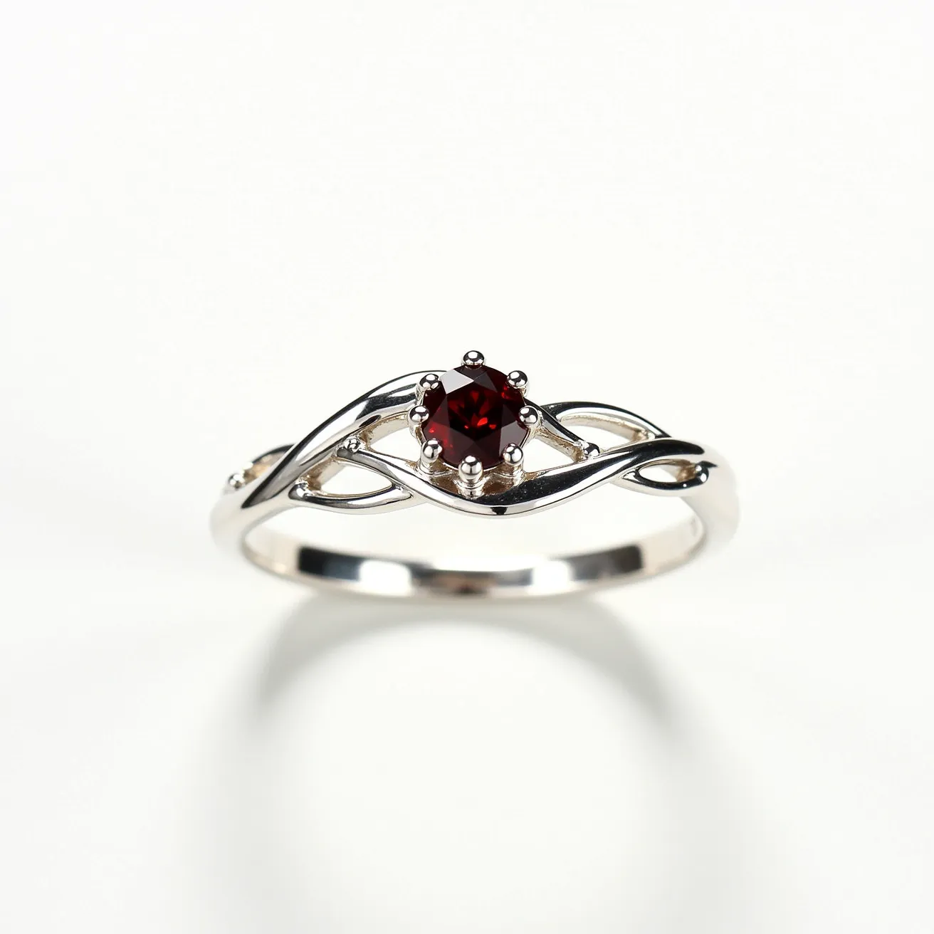 This garnet wedding ring features a captivating round-cut garnet stone set in a prong setting, allowing the deep red hue of the gemstone to be prominently displayed. The band is crafted from a polished silver metal, with a delicate intertwining design that adds a touch of elegance and sophistication. The setting securely holds the garnet in place, accentuating its vibrant color and brilliance. The overall design blends classic and modern elements, making it a timeless choice for a wedding ring.