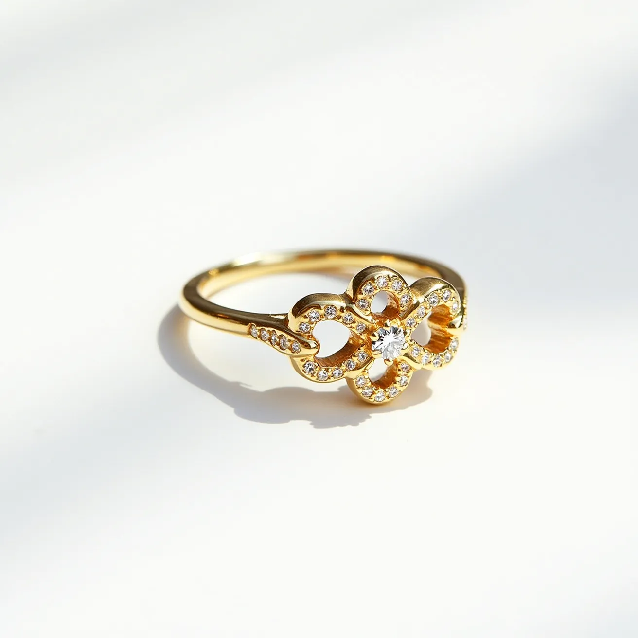 This gemstone ring features a delicate gold band that highlights an intricate floral-shaped setting at its center, adorned with a prominent round-cut diamond. The central diamond, sparkling brilliantly, is surrounded by smaller, round-cut diamonds embedded into the floral design, enhancing its elegance. The ring's petals are encrusted with these tiny stones, creating a seamless and shimmering effect. The band’s design, while minimal, complements the ornate central piece, creating a balanced and refined appearance. The overall craftsmanship reflects a harmonious blend of simplicity and opulence.