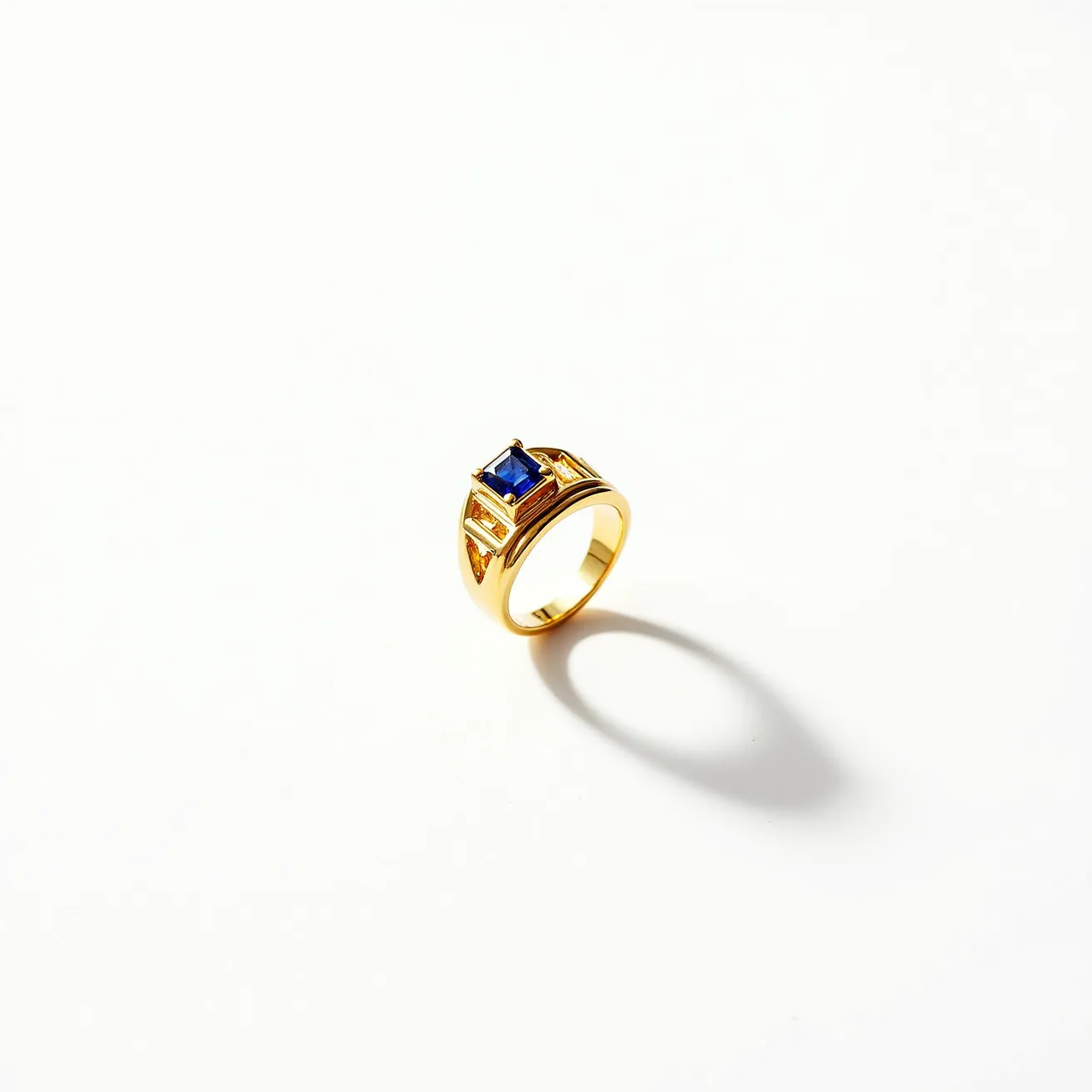 This gold thumb ring features a prominent, square-cut blue sapphire set in a sleek bezel setting. The sapphire is held at the center, adding a vibrant contrast to the ring's warm gold hue. The band has a modern design, elegantly showcasing the central stone. There are no additional clasps or attachments, allowing the ring's simplicity and the sapphire's rich color to be the focal points.