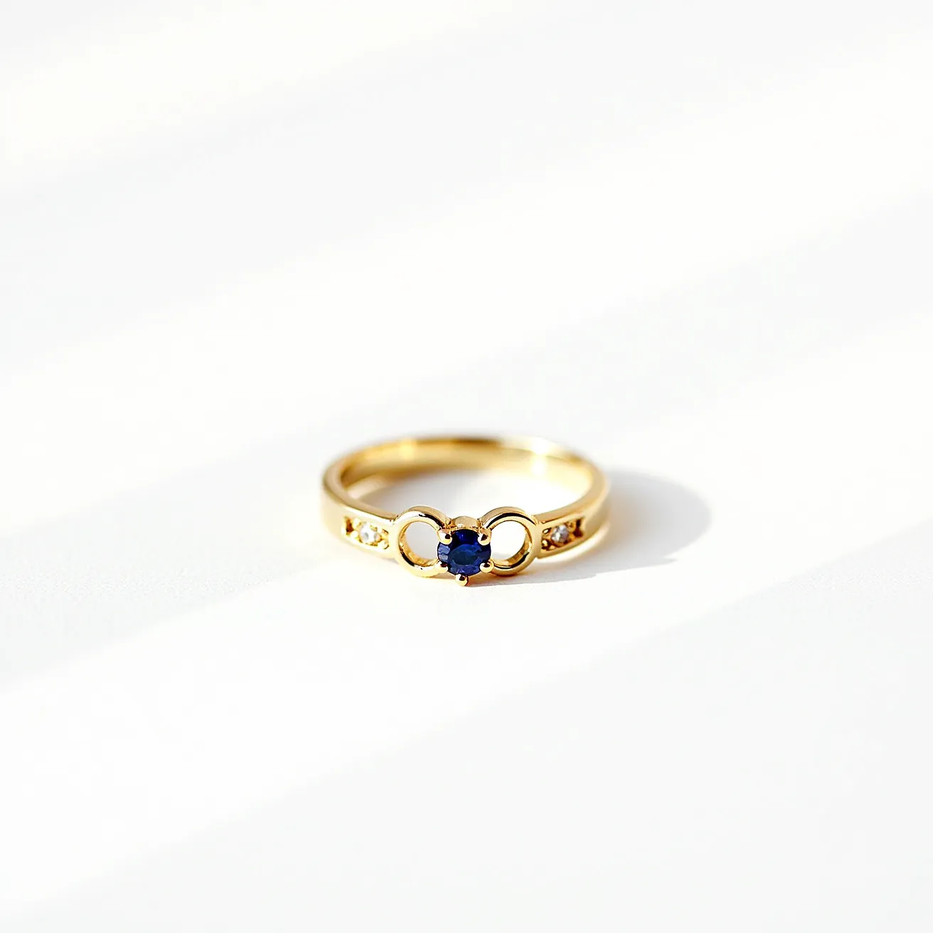 This gold wedding band features a central round-cut blue gemstone, likely a sapphire, elegantly set in a classic prong setting. On either side of the main stone, there are small round white gems, possibly diamonds, embedded into the gold band. The symmetrical design is enhanced by the integration of the stones within the lustrous gold material, providing a timeless and elegant appearance. No clasps or additional attachments are present, allowing the focus to remain on the harmonious blend of gold and gems.