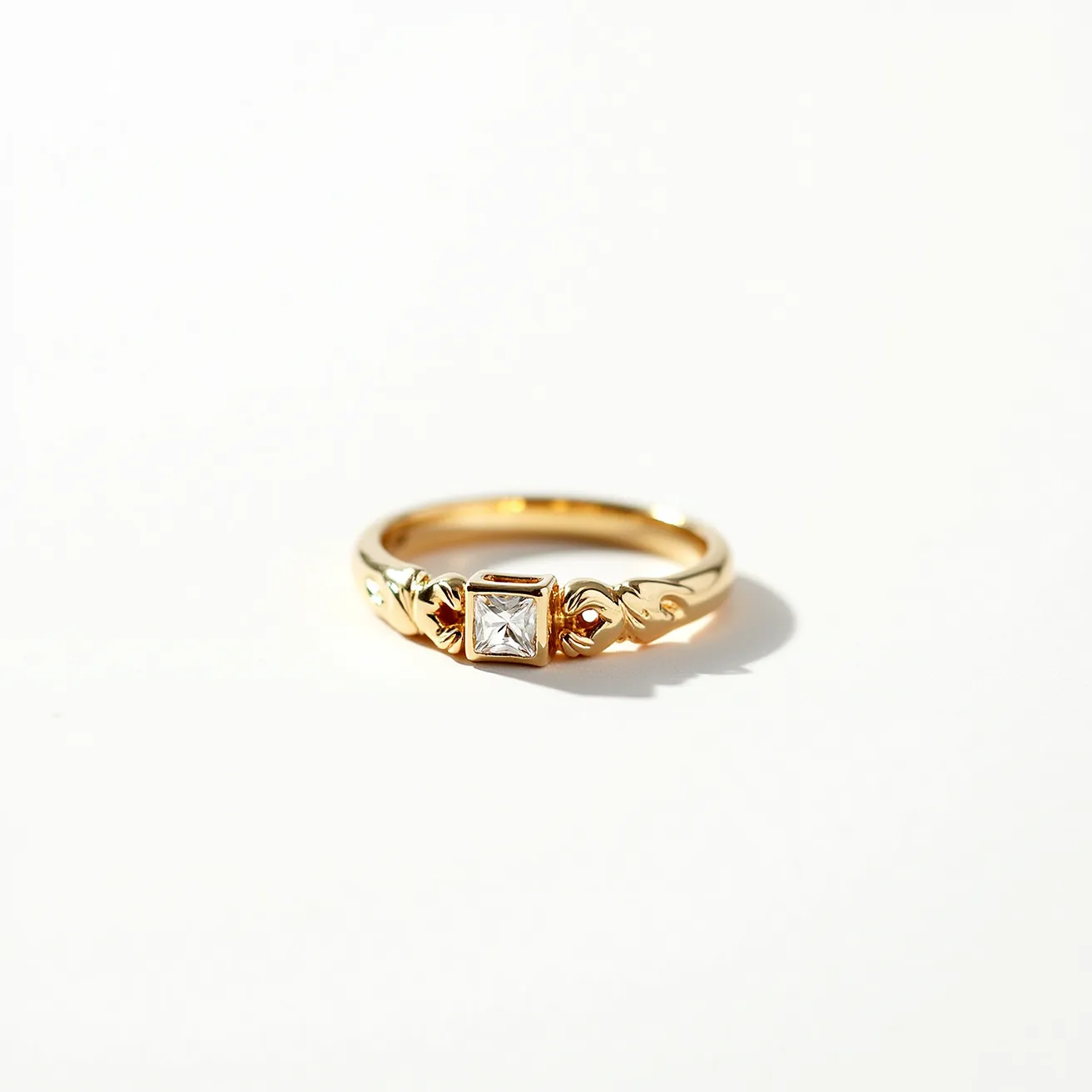 This gold wedding band is elegantly crafted with a sleek, polished finish. At the center, it features a prominent square-cut gemstone, which is securely held in place by a bezel setting. The design is further enhanced by ornate detailing flanking the central stone, adding a touch of intricate sophistication to the band. The elements combine to form a classic yet distinctive piece of jewelry.