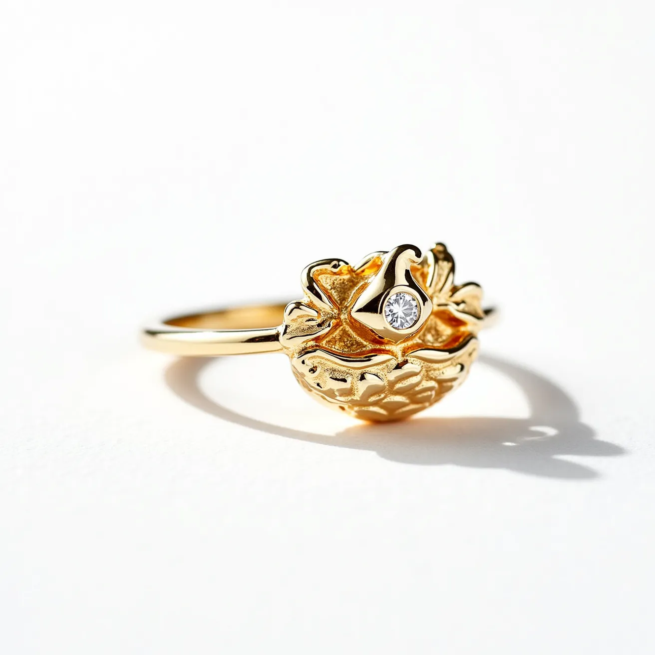 This golden bird ring features a detailed depiction of a bird nestled within an intricate nest design, crafted from a lustrous gold material. At the center of the bird's head, a small round gemstone, likely a diamond, is set in place. The stone is expertly cut, adding a brilliant sparkle to the piece, and is secured in a bezel setting that ensures its stability while enhancing its visual prominence. The band of the ring is simple, allowing the ornate bird and nest motif to remain the focal point. The craftsmanship reflects a balance of elegance and charm, suitable for those who appreciate nature-inspired jewelry pieces.