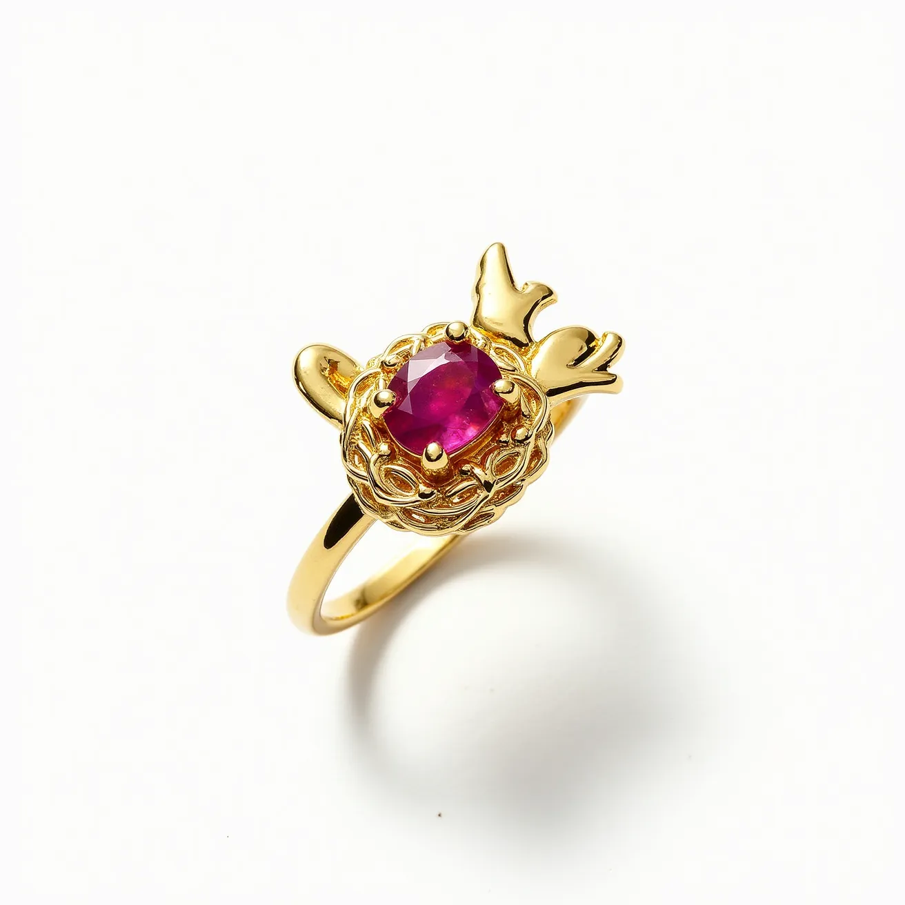 This golden bird ring features a beautifully ornate design, crafted primarily from gold and shaped to resemble a small bird perched atop an intricately detailed nest. At the center of the nest is an oval-cut gemstone with a striking deep pink hue, likely a ruby, securely held in place by four prominent prongs forming a classic claw setting. The ring band is smooth and polished, complementing the elaborate upper design and providing an elegant, seamless fit.