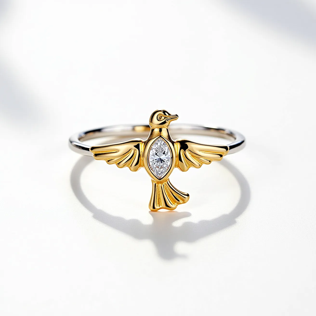 This golden bird ring features a striking design with the bird crafted in a rich gold tone, giving it an elegant and luxurious appearance. At the center of the bird, there is a brilliantly cut marquise diamond, set securely within the bird's body, drawing attention to its sparkling clarity and precision. The marquise cut is beautifully showcased, enhancing the bird's sophisticated look. The band of the ring is sleek and polished, likely made of a complementary metal, providing a sturdy and comfortable fit. The bird's wings and tail are artistically detailed, adding to the overall charm and uniqueness of the piece.