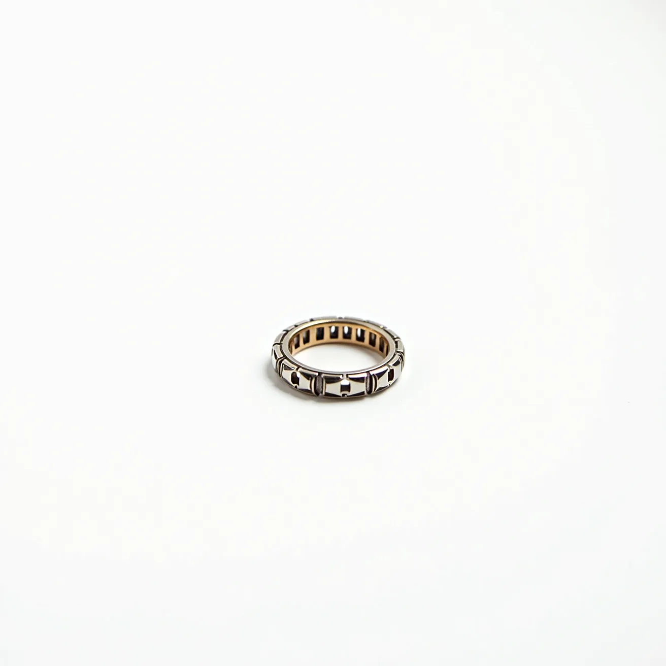 This groove ring features a modern design crafted from a combination of metals with contrasting tones, likely incorporating elements such as stainless steel or tungsten for durability and a sleek appearance. The exterior displays a pattern of evenly spaced grooves that add a textural element to its overall aesthetic. The interior of the ring showcases a polished finish for comfort. There are no visible gems, stones, or settings integrated into this design, nor are there any clasps or additional attachments, emphasizing its minimalist style.