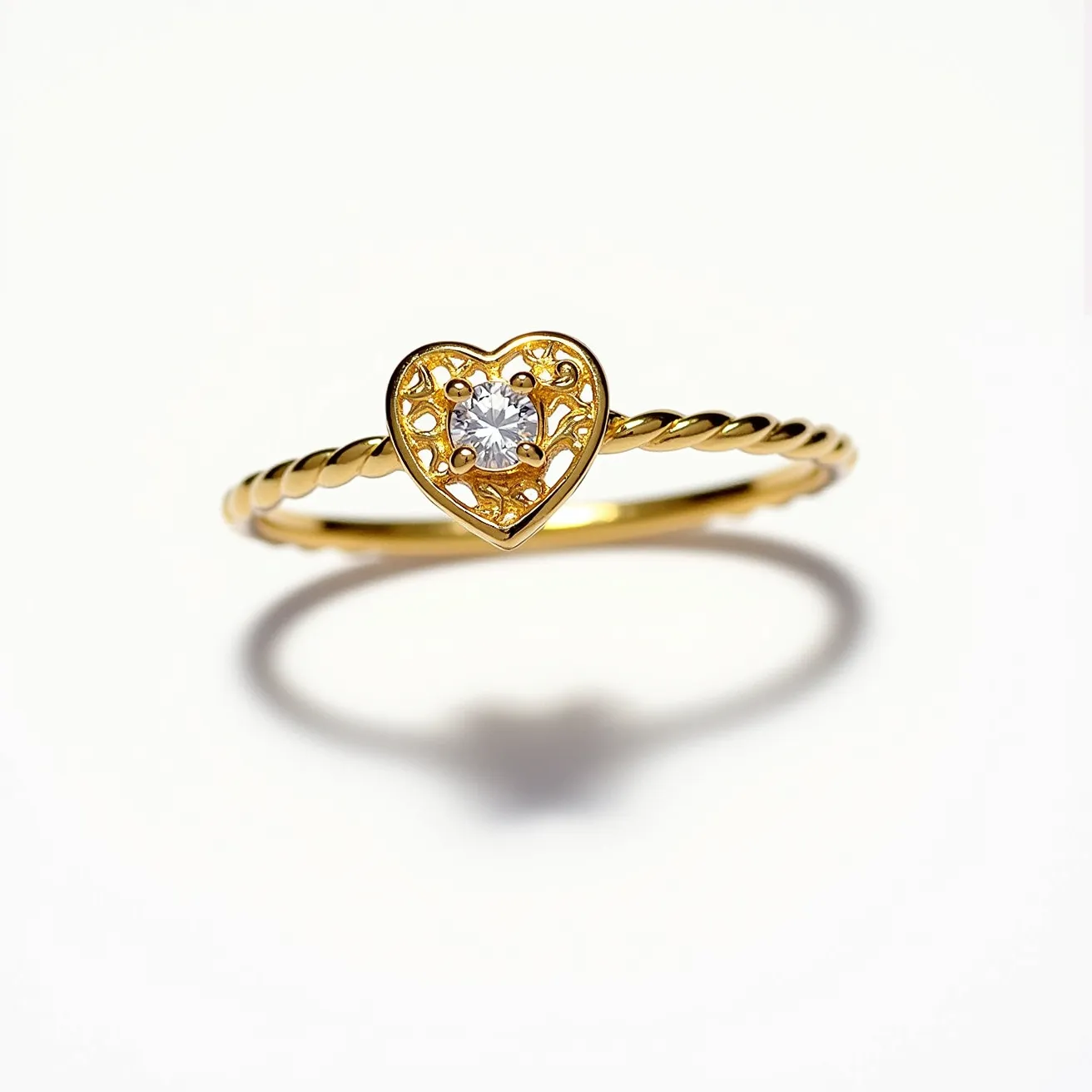 This heart promise ring features a delicate gold band with a twisted design, adding an elegant touch to its overall appearance. At its center is a heart-shaped motif, intricately crafted with fine details that evoke a sense of romance. Set within this motif is a round-cut clear gemstone, held securely in place by a classic prong setting, allowing the stone to catch the light beautifully. The combination of the gold band and the centrally set gemstone creates a timeless piece that symbolizes commitment and affection.