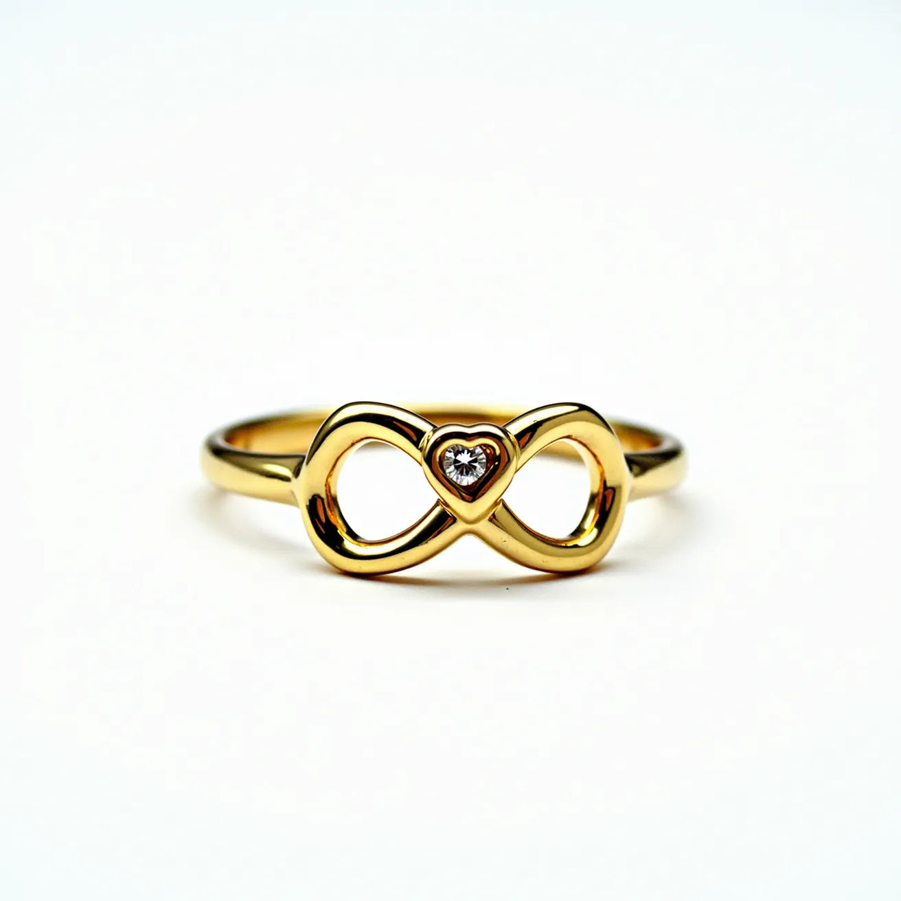 This heart ring features a sleek gold band, elegantly designed into an infinity symbol at the center. Nestled within the heart-shaped center is a small, round diamond, expertly cut to enhance its sparkle and brilliance. The diamond is securely set in a bezel setting, providing a modern and sophisticated look. The ring's design is simple yet symbolic, combining timeless elegance with meaningful representation.