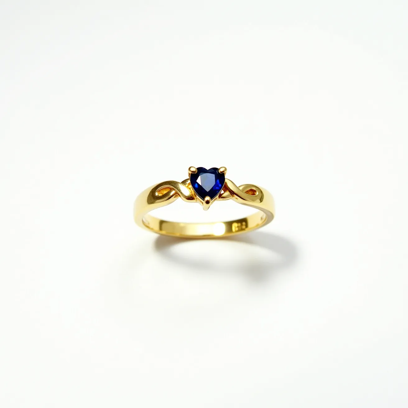 This heart wedding ring features a beautifully crafted heart-shaped blue sapphire set in an elegant gold band. The sapphire is carefully cut to enhance its vibrant hue and brilliance, held securely in place by a classic prong setting. The band itself is smooth and polished, providing a timeless and luxurious appearance that complements the gemstone's color. The ring exemplifies a harmonious blend of rich gold and the deep blue of the sapphire, making it a perfect symbol of love and commitment.