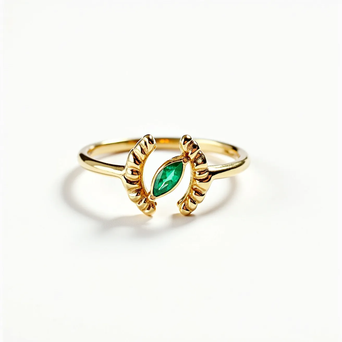 This horseshoe ring is crafted from gold, featuring a sleek band that elegantly curves into a horseshoe shape. The focal point of the design is a marquise-cut green gemstone, possibly an emerald, securely set between the curving ends of the horseshoe. The gemstone is held in place with a bezel-like setting that complements the overall design, enhancing the ring’s luxurious appearance without any additional clasps or attachments. The ring combines classic symbolism with a modern aesthetic, making it both a stylish and meaningful piece of jewelry.