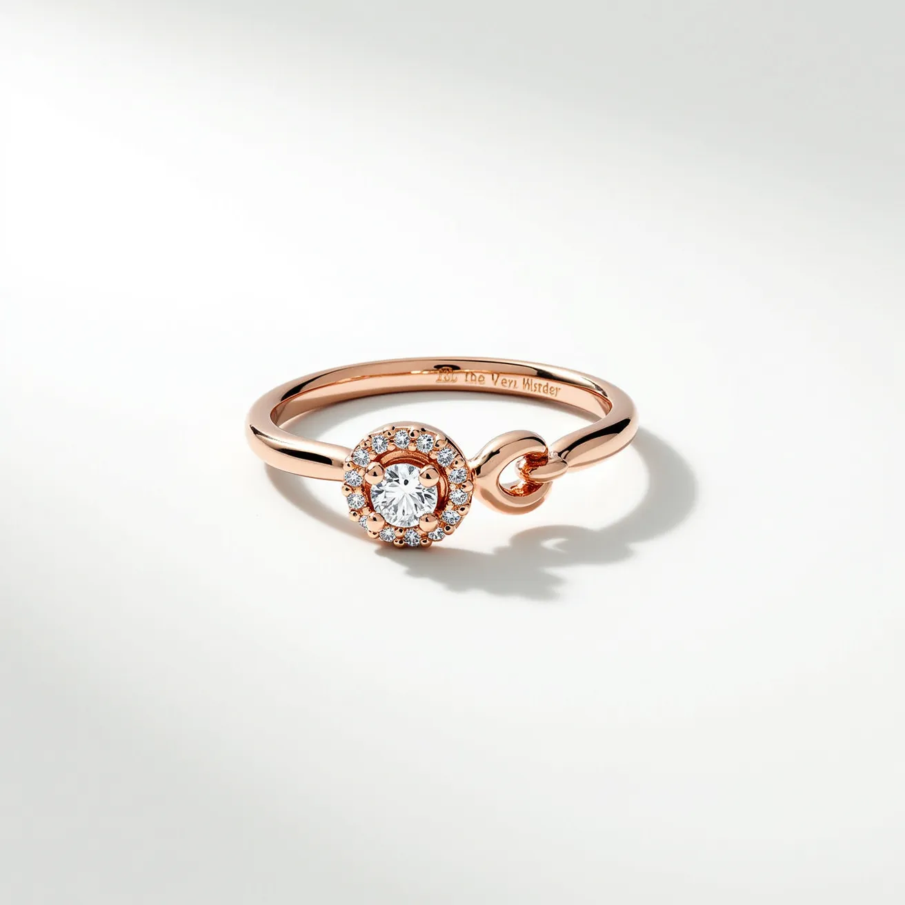 This infinity ring features a sleek band crafted from a rose gold metal, highlighting its elegant design. The focal point is a round-cut diamond at the center, encircled by a halo of smaller diamonds, enhancing its brilliance. The diamonds are set securely in prong settings, ensuring stability and maximum light reflection. Notably, there is an imaginative twist or knot incorporated into the band, symbolizing continuity and eternal connection. The ring does not include a traditional clasp or attachment, relying on its continuous form to represent the infinity motif.