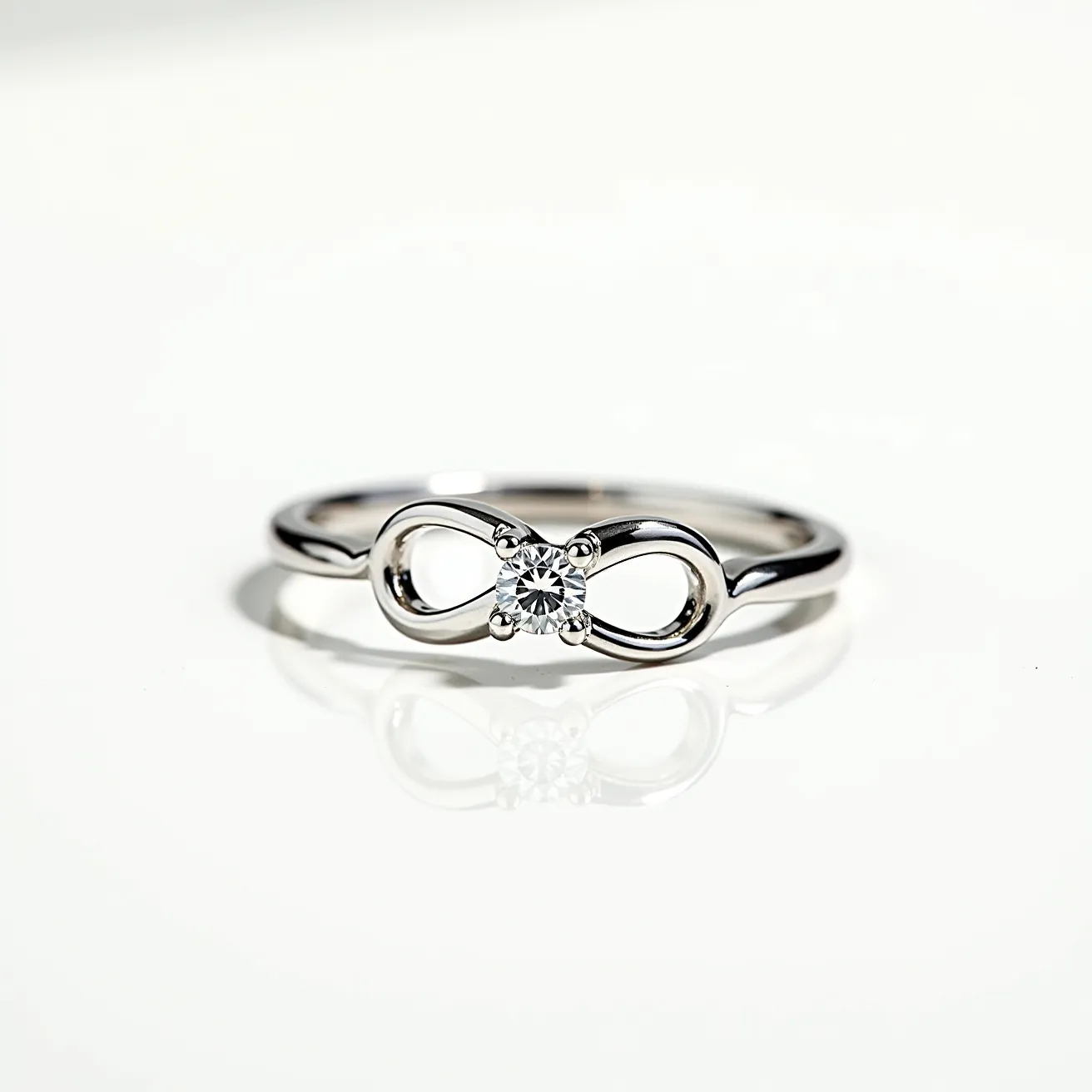 This infinity ring elegantly combines sleek metallic elements with a sparkling gemstone centerpiece. The metal appears to be a polished silver or white gold, forming a continuous loop that embodies the infinity symbol. At the center, a single round-cut diamond is securely set, drawing focus with its clear, radiant quality. The stone is held in place by a classic four-prong setting, ensuring stability and prominence. The band is smooth and unobtrusive, allowing the infinity motif and diamond to stand out as the focal points.