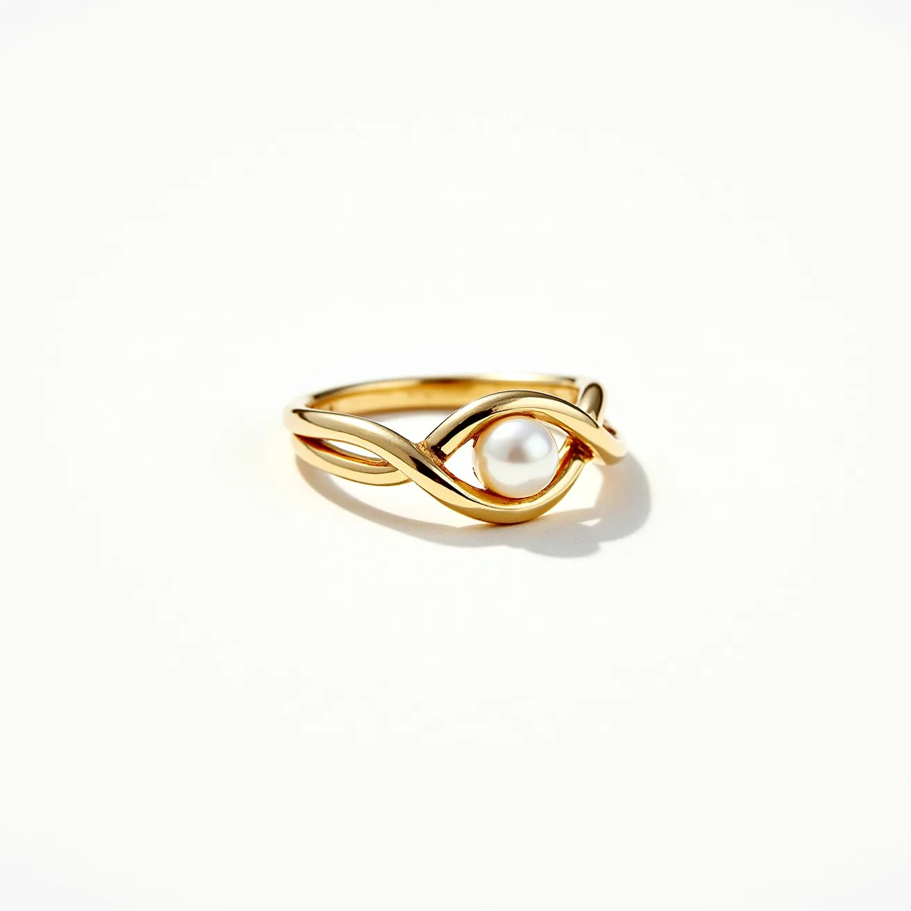 This knot ring showcases a graceful, twisted design made from gold, intricately weaving around a central white pearl. The pearl, with its lustrous round cut, is elegantly embraced by the flowing lines of the gold band, securely held in place without any visible prongs or settings. The seamless flow of the gold creates an impression of infinity, with the pearl as the focal point, adding a touch of sophistication and elegance to the overall aesthetic. The ring does not feature any visible clasps or additional attachments, emphasizing the simplicity and beauty of the knot design.