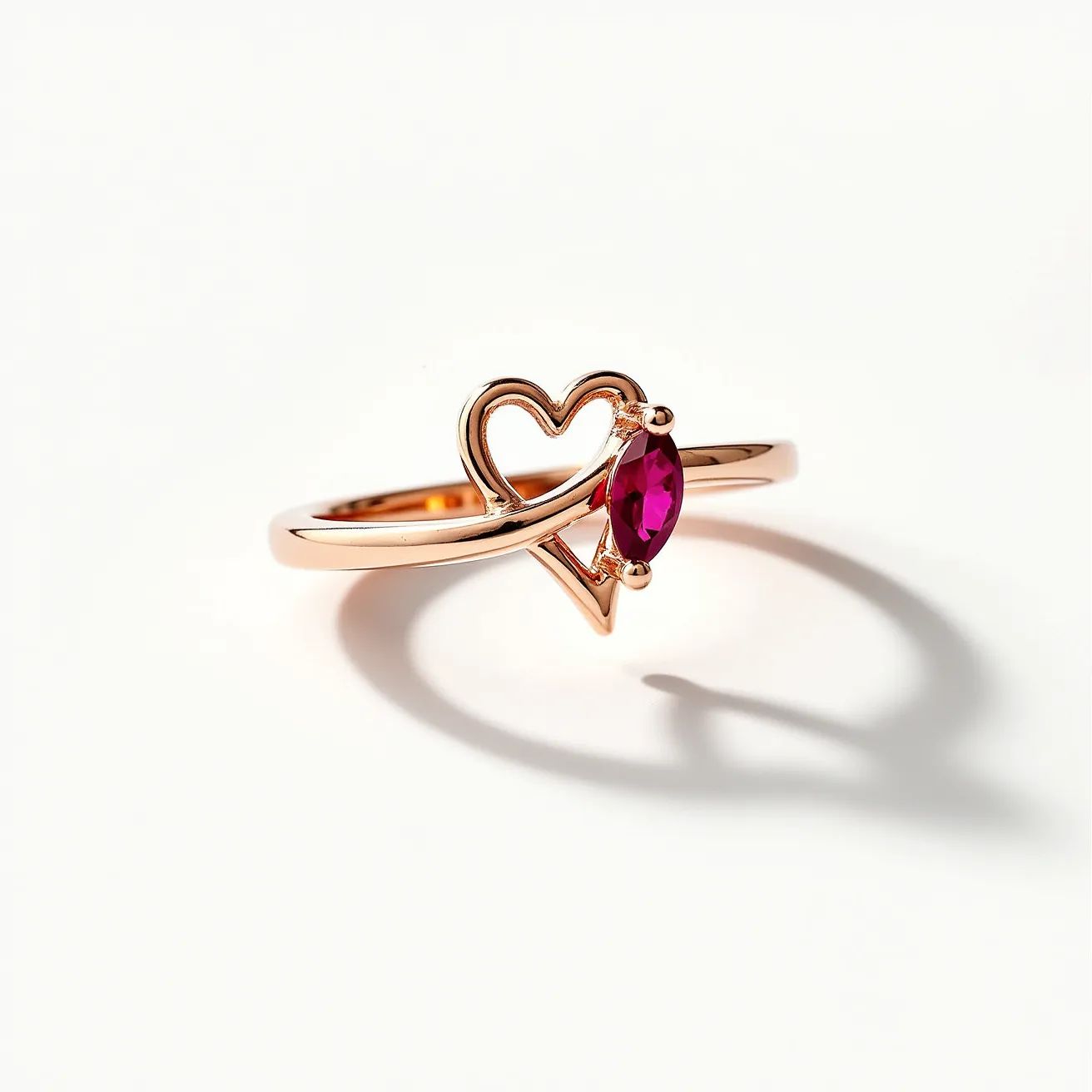 This love ring features a delicate design crafted from a warm, rose-colored metal that beautifully complements the centerpiece. At its heart sits a marquise-cut red gemstone, likely a ruby, set in a prong setting to enhance its brilliance and secure its position. The ring's band gracefully integrates a stylized heart motif, adding a romantic touch to the overall design. The setting of the gemstone and the open heart seamlessly blend into the band, creating a harmonious balance between the elements.