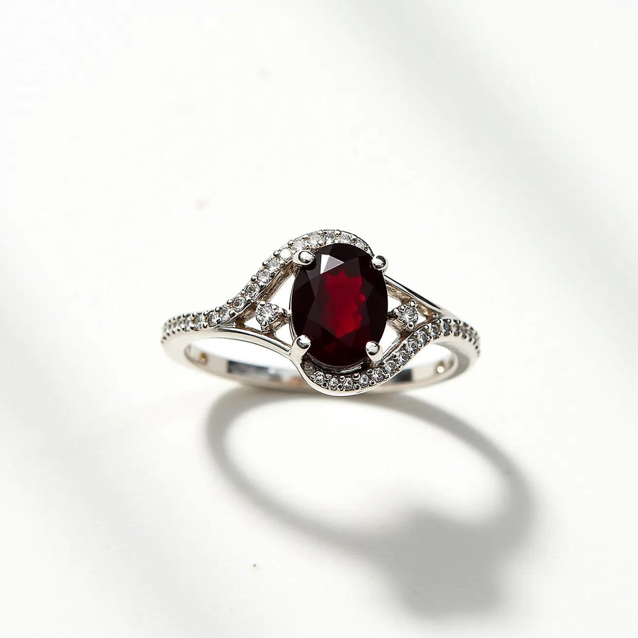 This March birthstone ring showcases a prominent oval-cut gemstone set at its center, encased in a sophisticated prong setting. Surrounding the central gem, the band is adorned with smaller round stones, likely diamonds, adding a touch of sparkle and elegance. The band itself appears to be crafted from a polished metal, possibly white gold or platinum, contributing to the ring's luxurious appearance. The design features intricate detailing along the band, enhancing its overall aesthetic appeal.