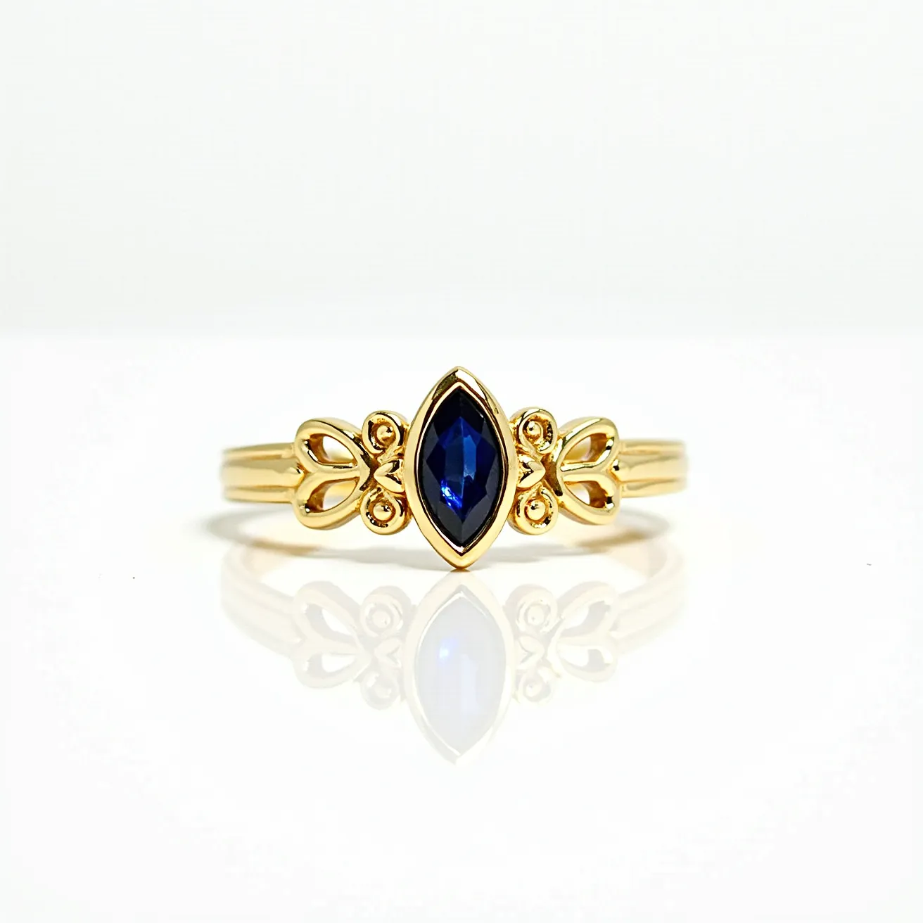 This marquise engagement ring features a central marquise-cut blue gemstone elegantly set in a yellow gold band. The band showcases intricate filigree detailing on either side of the stone, enhancing its overall elegance and vintage appeal. The setting securely holds the gemstone, emphasizing its elongated shape and deep color. The gold band complements the blue of the gemstone, creating a harmonious and luxurious appearance that is both unique and eye-catching.