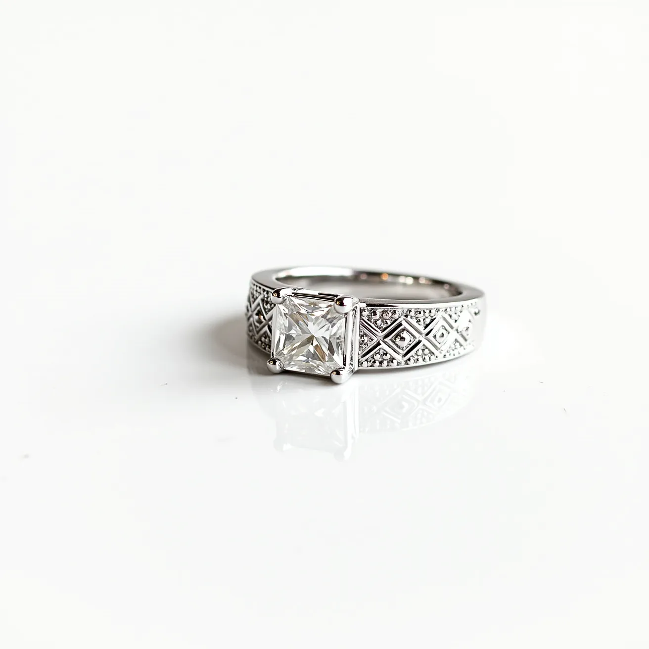 This men's engagement ring features a square-cut diamond set in a prong setting, highlighting the gem's brilliance and clarity. The band is made of polished metal, likely white gold or platinum, with intricate engraved details, presenting a pattern of geometric designs that add texture and character to the piece. The craftsmanship of the band complements the central diamond, creating a balanced and sophisticated look. The setting is secure, ensuring the central stone is held firmly in place while enhancing its visual appeal.