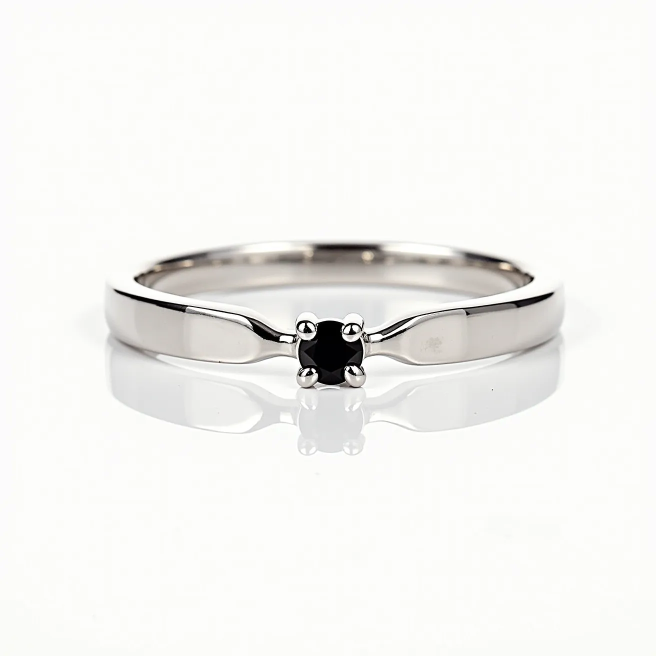 This men's engagement ring features a sleek band crafted from polished white gold, showcasing a minimalist design. At its center, the ring is adorned with a single round-cut black gemstone, securely held in place by a classic four-prong setting. The ring's simple yet elegant style is emphasized by its clean lines and the subtle contrast between the bright metal and the dark stone. There are no additional embellishments or clasps, emphasizing the ring's understated sophistication.