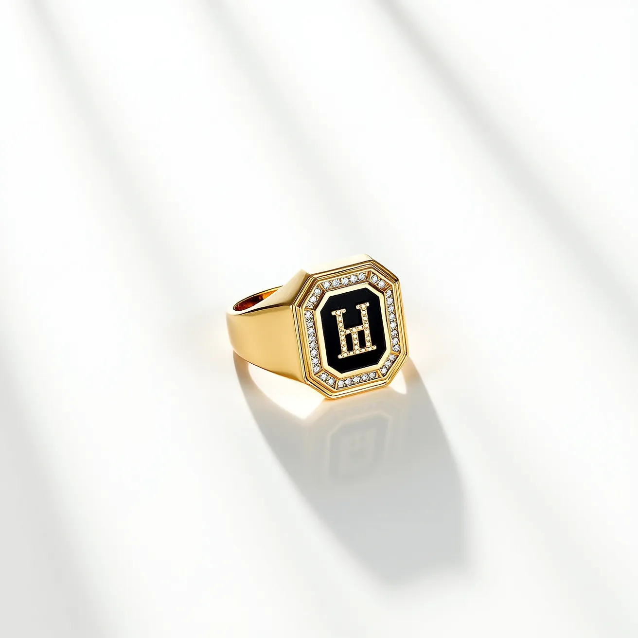 This men's pinky ring features a striking design with a gold band, providing a sturdy and luxurious foundation. The centerpiece of the ring is an octagonal face adorned with a black enamel background, showcasing a prominent gold "H" inlay. Surrounding the central black enamel is a series of small, round-cut diamonds, each meticulously set in a pave setting. The combination of these materials and design elements creates a piece that is both elegant and bold, embodying a sense of refinement and personal style.