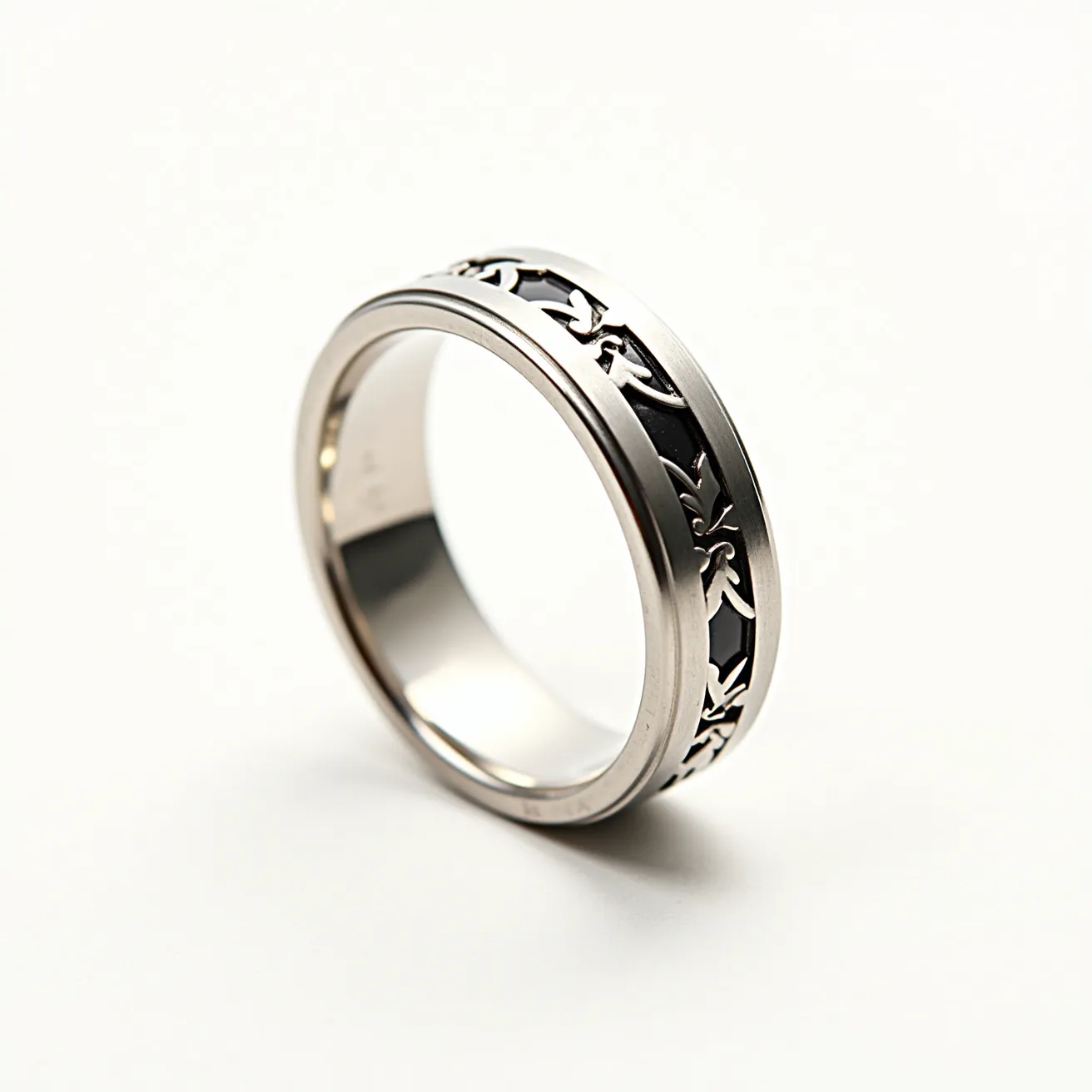 This men's pinky ring is crafted from metal, likely stainless steel or a similar alloy, featuring a sleek and polished finish. The centerpiece is an intricately cut pattern, possibly in a leaf or vine design, which runs along the circumference of the band. This cut-out design reveals a darkened underlay, creating a striking contrast with the shiny metal exterior. The ring does not appear to have any gemstones, clasps, or additional attachments, emphasizing the elegant simplicity of its design.