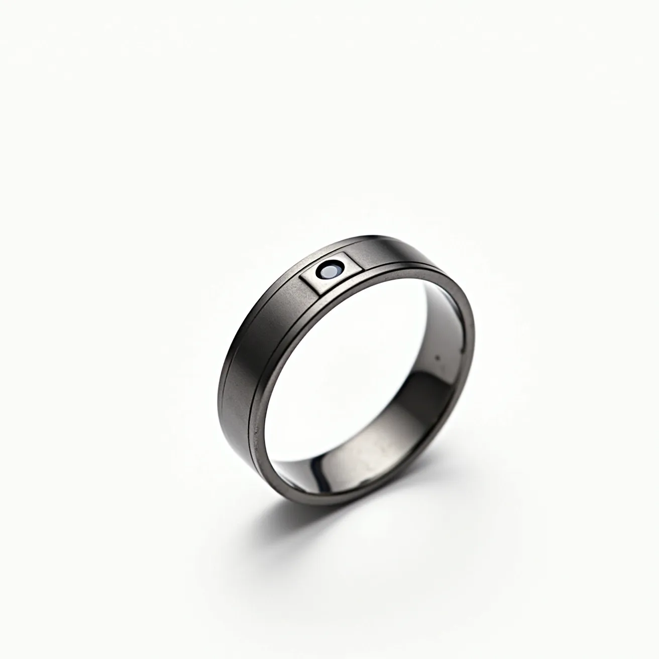 This men's ring features a sleek and modern design, crafted from a dark metallic material that gives it a contemporary and sophisticated appearance. It prominently displays a small, round gemstone centrally set within a rectangular inset on the band, adding a touch of elegance to its streamlined look. The stone appears to be securely bezel-set, enhancing its subtle yet distinctive character. The ring's smooth interior suggests comfort for the wearer, and its minimalist style is both eye-catching and understated.