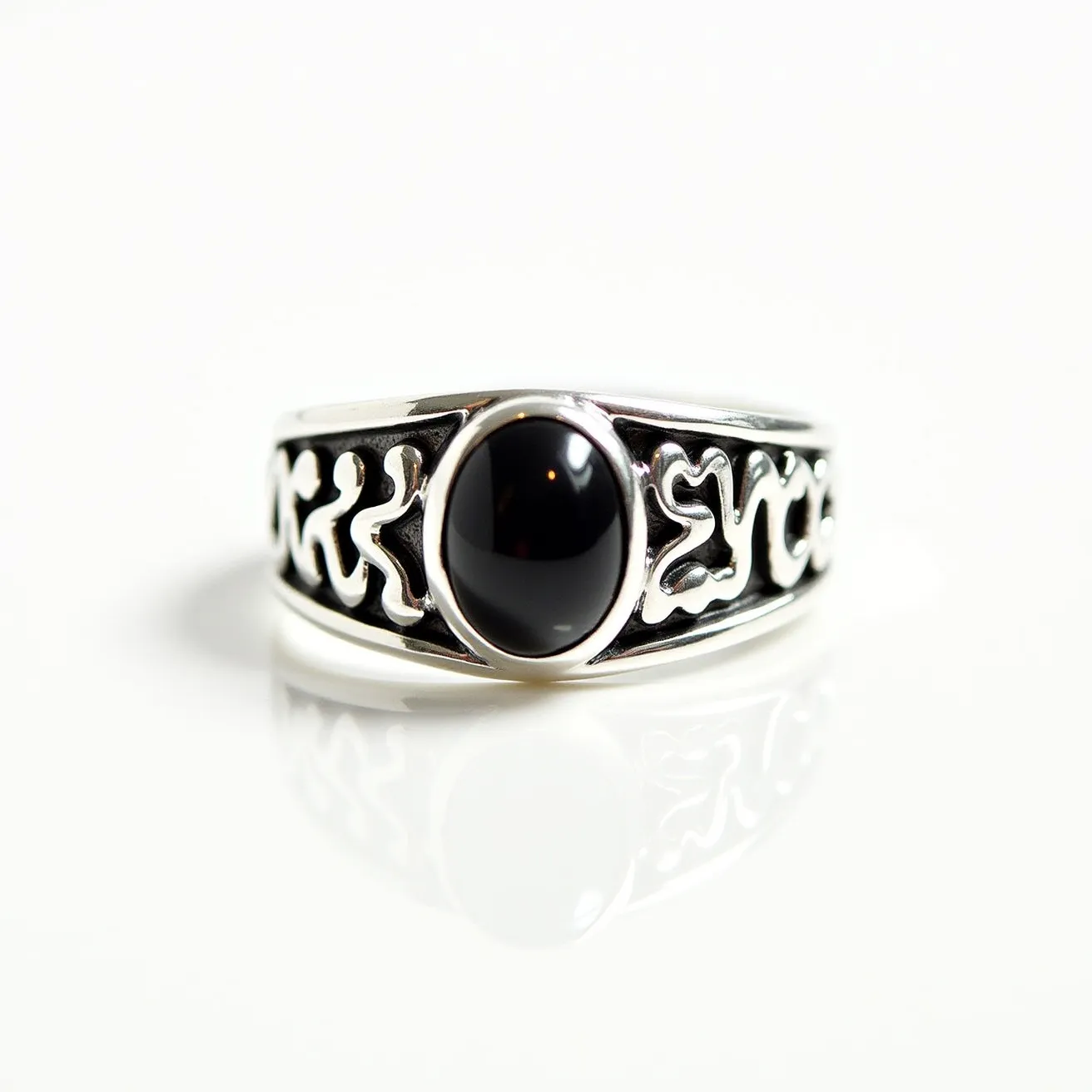 This men's silver ring features an eye-catching black oval stone set in a bezel setting, creating a sleek and polished appearance. The silver band is adorned with intricate organic patterns, giving it a bold and stylish look. The combination of silver and the dark stone provides a striking contrast, making it a statement piece suitable for various occasions. The craftsmanship is evident in the design, reflecting a balance between modern elegance and traditional detailing.