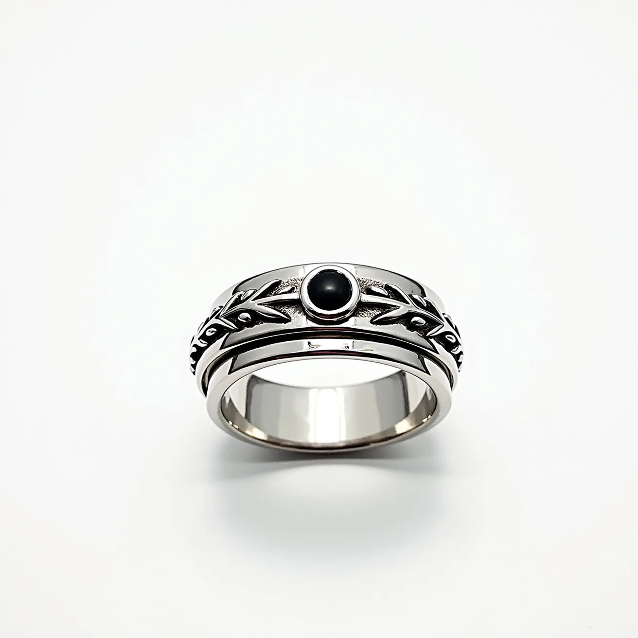 This men's spinner ring is crafted from a sleek silver metal and features an intricately designed band with leaf patterns. At the center of the ring, there's a round black stone set in a bezel setting, adding a striking focal point to the design. The ring includes a movable outer band, typical of spinner rings, allowing for a tactile and calming experience for the wearer. The combination of the metallic shine with the deep black stone creates a bold and sophisticated look.