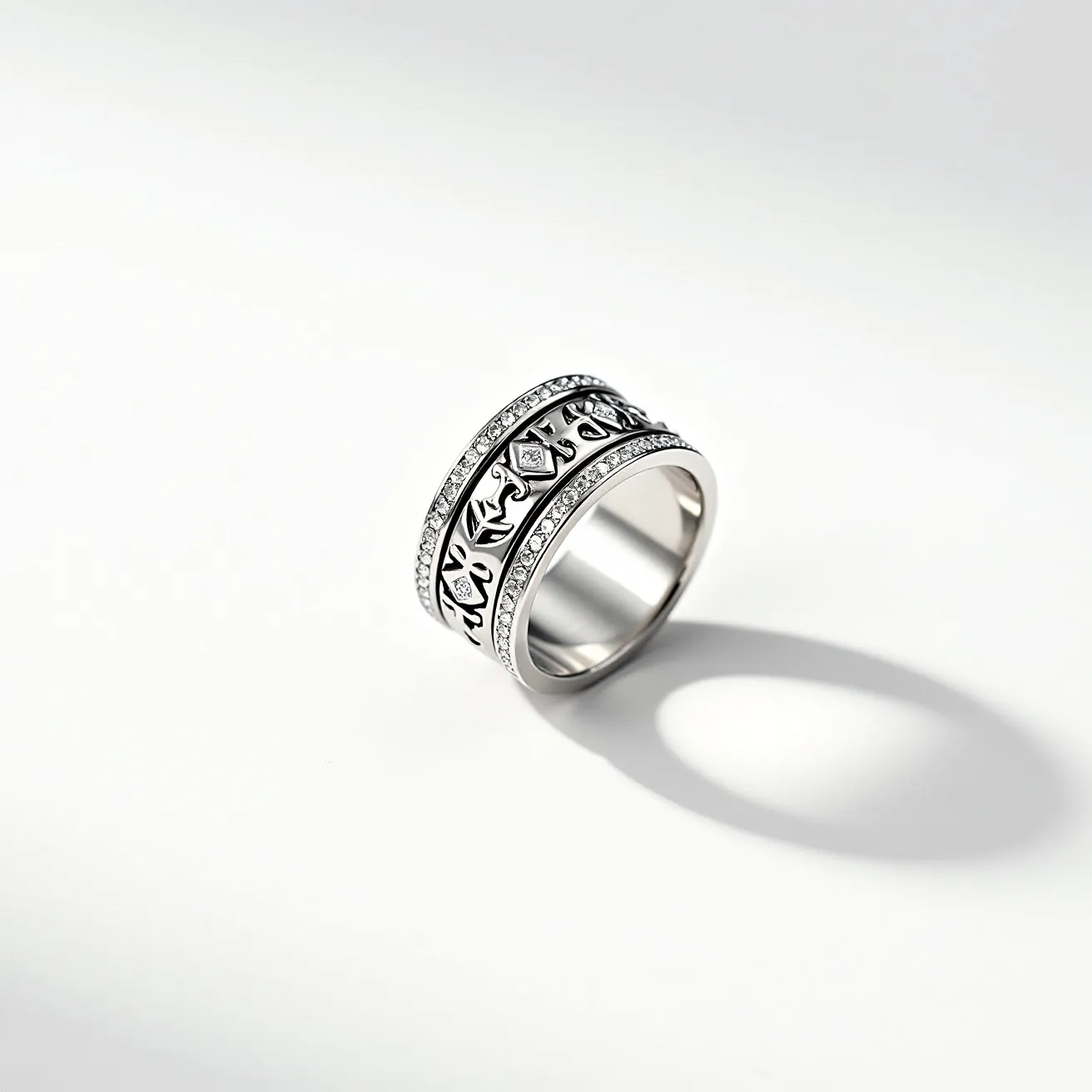 This men's spinner ring features an elegant design crafted from a silver-toned metal, exhibiting a robust and stylish appearance. The central band is adorned with intricate engravings that add an element of sophistication. Surrounding this central band are two outer bands set with small, round-cut clear gems in a channel setting, enhancing the ring's luxurious feel. The spinner mechanism allows the central band to rotate smoothly, adding both a functional and decorative element to the piece. There are no clasps or attachments, as the ring's solid, continuous design embodies a seamless aesthetic.