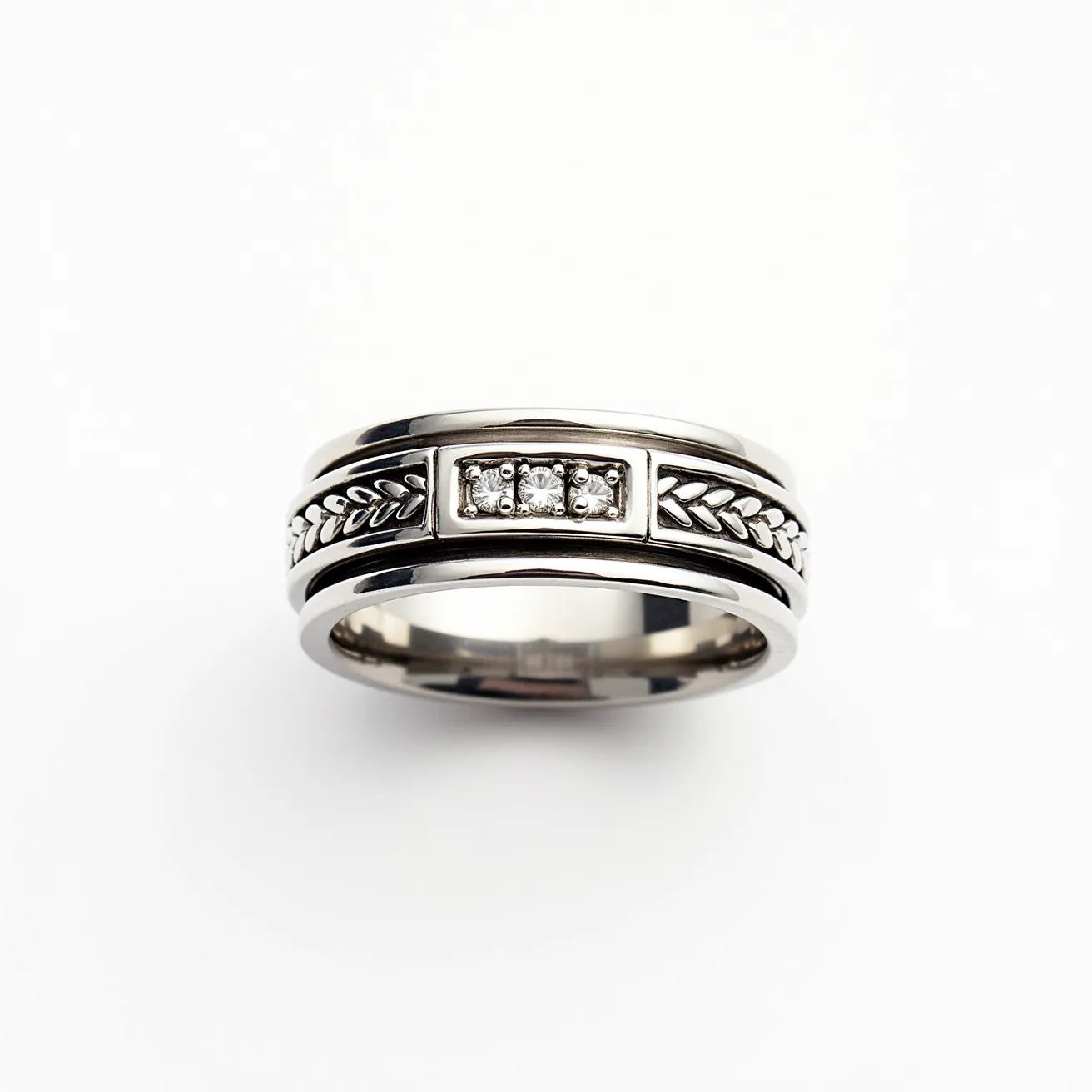 This men's spinner ring features a sleek design crafted from a polished silver or white gold metal. The central band is adorned with a captivating row of three small, round-cut diamonds set in a secure bezel setting, which offers both elegance and durability. The outer band showcases intricate leaf motifs that encircle the ring, adding a touch of texture and visual interest. The spinner mechanism allows for a smooth rotation of the central band, providing a unique tactile experience. Overall, the combination of metal and gemstones creates a distinctive and stylish accessory.