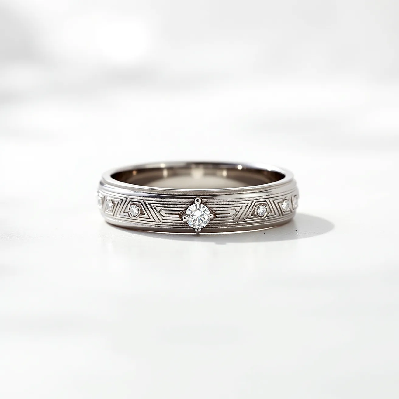 This men's wedding band features a sleek metal band, likely crafted from white gold or platinum, giving it a polished and sophisticated appearance. The band is adorned with a series of sparkling diamonds, expertly set in a geometric pattern. The largest diamond is centrally positioned and appears to be a round cut, secured in a bezel setting which adds a modern touch to the overall design. Smaller diamonds are symmetrically placed along the band, enhancing its elegance and visual continuity. The ring does not include any clasps or attachments, maintaining a seamless, circular form.