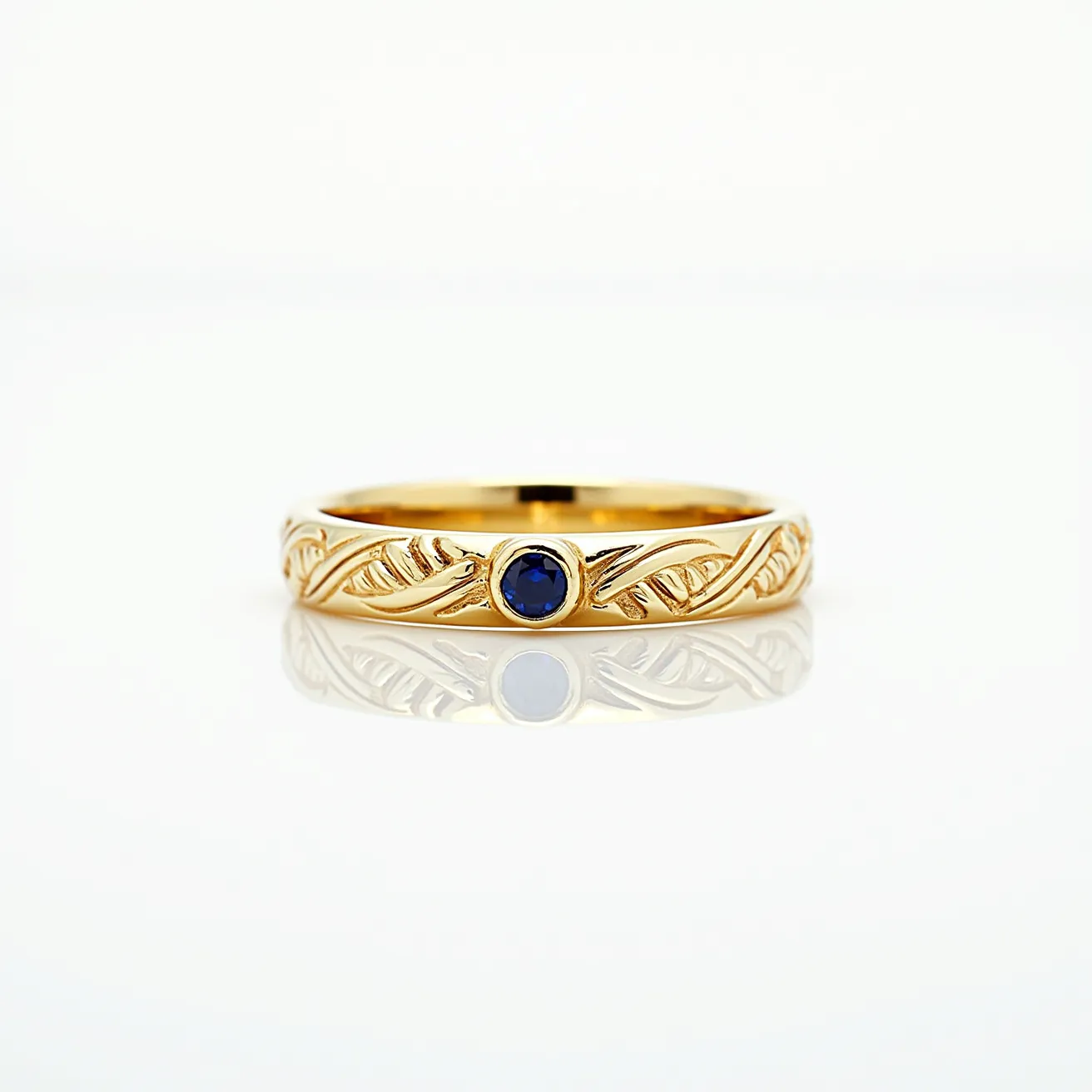 This men's wedding band features a refined design crafted from polished gold, adorned with intricate engraving along the band that enhances its elegant look. At the center of the ring, a single round sapphire is securely set in a bezel setting, providing a striking contrast against the gold. The absence of a clasp or attachment emphasizes its streamlined and seamless design, making it a sophisticated symbol of commitment.