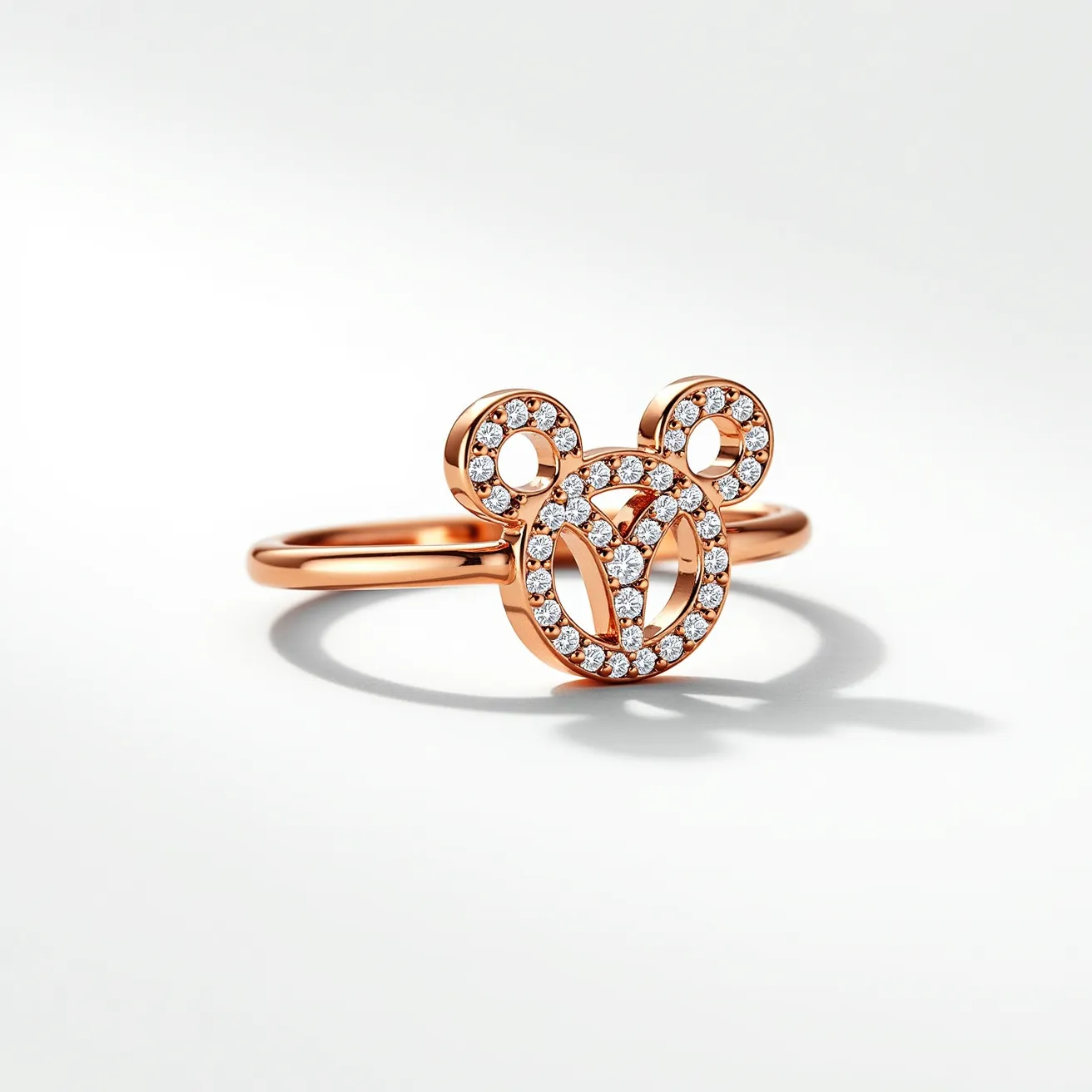 This Mickey Mouse ring features a stylish design crafted from rose gold, forming the iconic Mickey Mouse silhouette. The centerpiece is encrusted with small, round-cut clear gems, likely diamonds, which are pavé set to enhance the ring's sparkle and allure. The band itself is a simple, polished rose gold, providing a sleek and elegant look that highlights the playful yet sophisticated charm of the ring's design. The combination of materials and the meticulous setting of the gems make this piece both a whimsical and luxurious accessory.