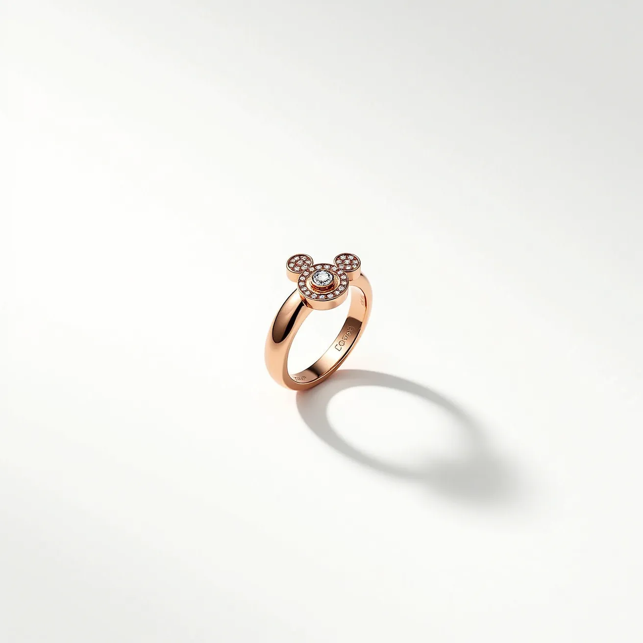 This Mickey Mouse ring features a rose gold band, complemented by a stylized Mickey Mouse head design on top. The head is adorned with small, round-cut diamonds, set in a delicate pavé arrangement, enhancing the iconic silhouette. The central part of the head includes a slightly larger stone, intricately set to draw attention. The ring showcases a polished finish, giving it a sleek and elegant look. There are no visible clasps or attachments, as the design is streamlined for a comfortable fit.