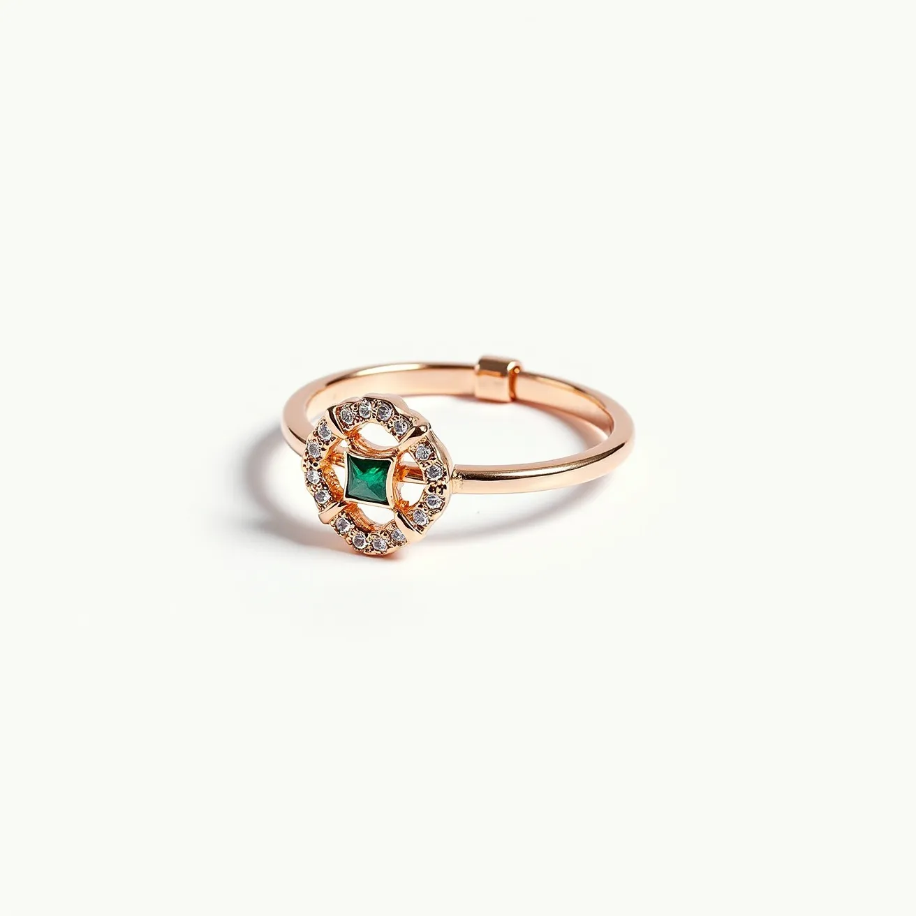 This midi ring features a sleek, rose gold band adorned with a striking centerpiece. At the heart of the design lies a square-cut green gemstone, likely an emerald, securely mounted in a prong setting. Surrounding the central stone is a halo of small, round, clear stones, possibly diamonds, enhancing the ring’s elegant aesthetic. The clasp appears to be a simple band style without any additional attachments, ensuring a minimalist yet sophisticated appearance.