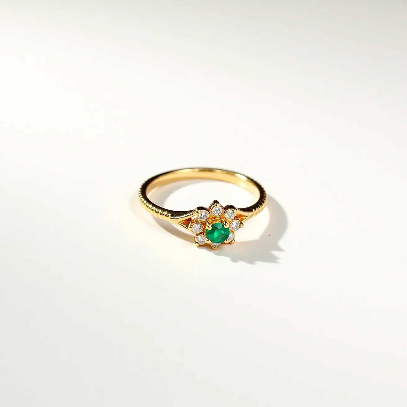 This midi ring features a gold band and is adorned with a central round-cut emerald, set within a delicate floral arrangement. Surrounding the emerald are multiple small, round-cut diamonds that enhance the design and add a touch of sparkle. The diamonds are secured in prong settings, allowing light to pass through and maximize their brilliance. The ring has a polished finish and a simple, seamless design without any clasps or attachments, focusing attention on the exquisite gemstone arrangement.