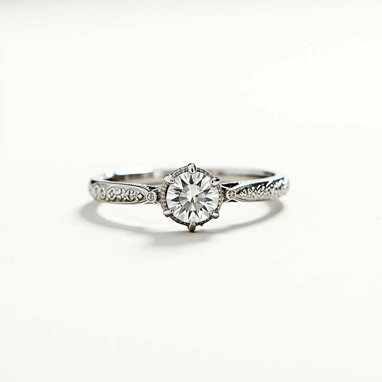 This moissanite promise ring features a central round-cut moissanite stone, expertly set in a classic six-prong setting. The band is crafted from what appears to be a lustrous white metal, such as sterling silver or white gold, embellished with intricate milgrain detailing and additional small accent stones that enhance its elegance. The combination of the main gemstone's brilliance and the detailed band creates a harmonious and refined look, suitable for marking significant promises or commitments.