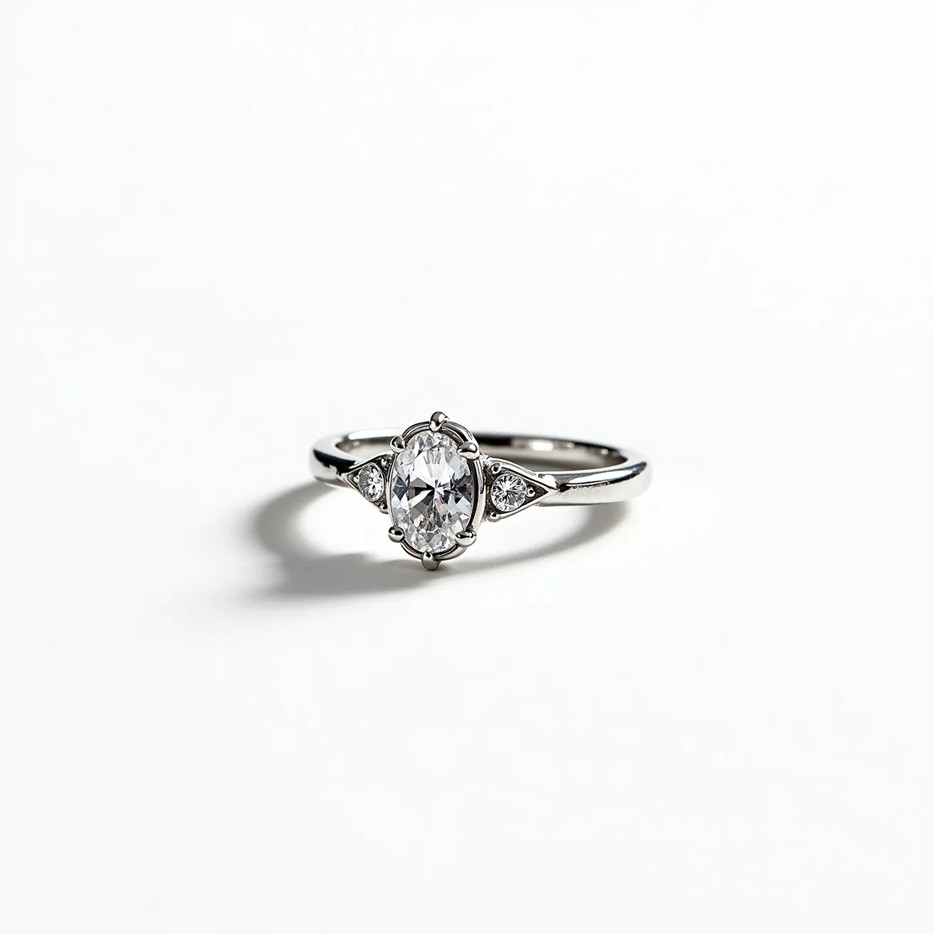 This moissanite promise ring showcases a captivating oval-cut moissanite stone at its center, held securely by a classic prong setting. Flanking the central stone are two small, triangular accent stones on either side, adding a touch of sophistication and sparkle. The band is elegantly crafted from polished metal, likely white gold or platinum, providing a sleek, modern aesthetic that complements the brilliance of the moissanite. The overall design is both elegant and timeless, making it an ideal symbol of commitment and promise.